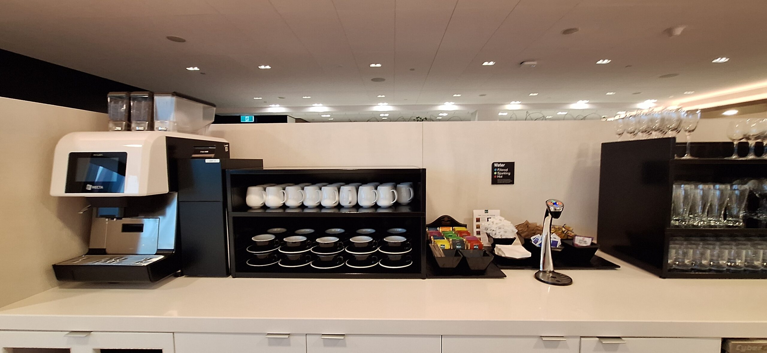 a coffee machine and coffee cups on a shelf