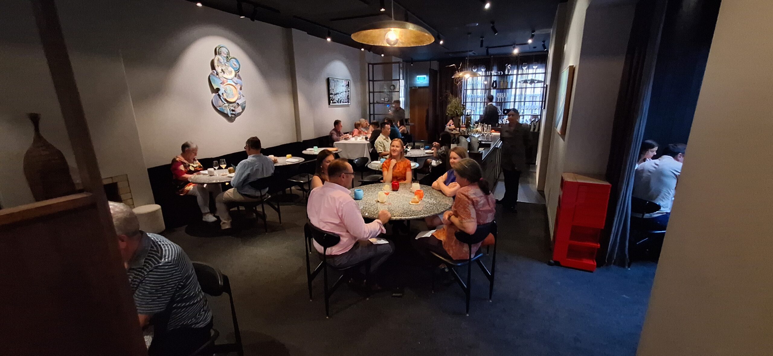 a group of people sitting at tables in a restaurant