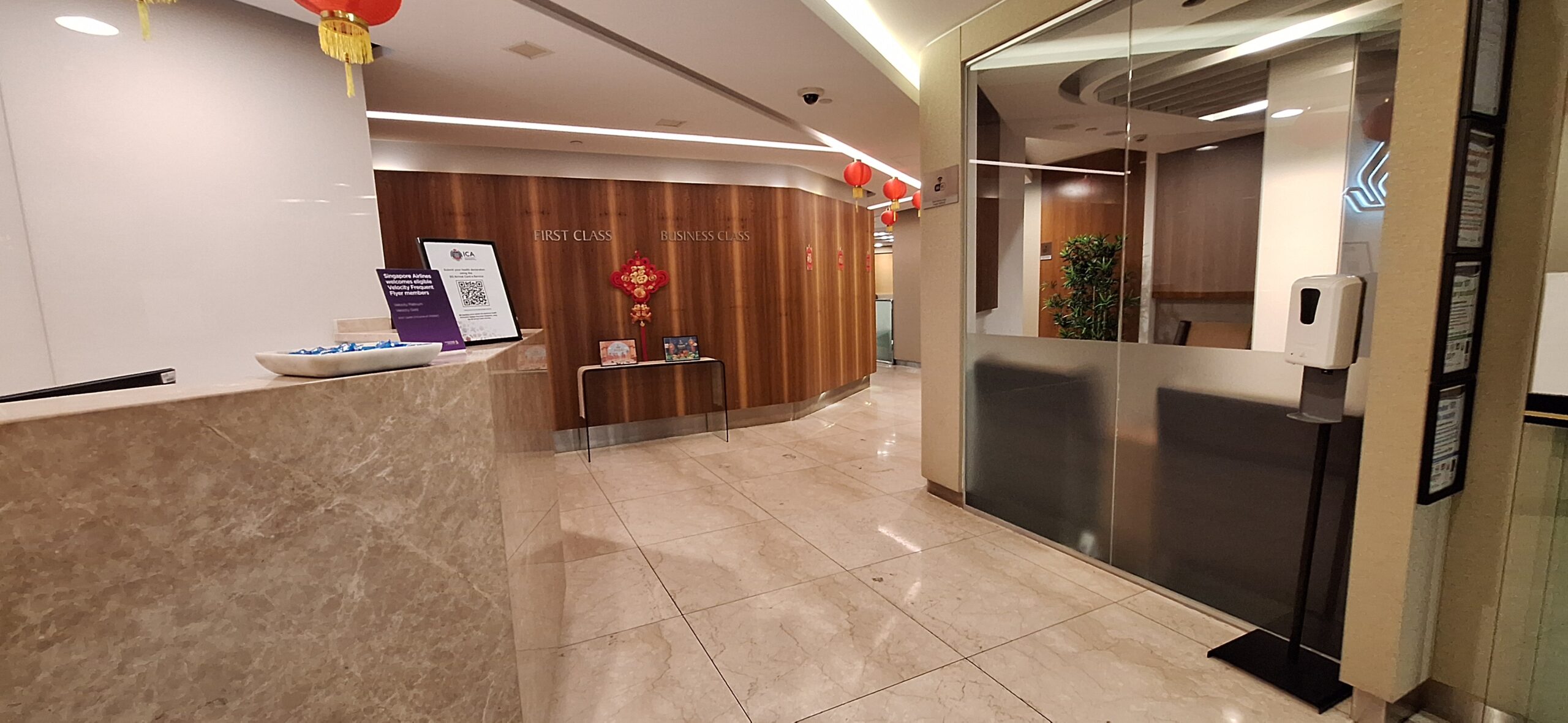 a hallway with a glass door and a desk