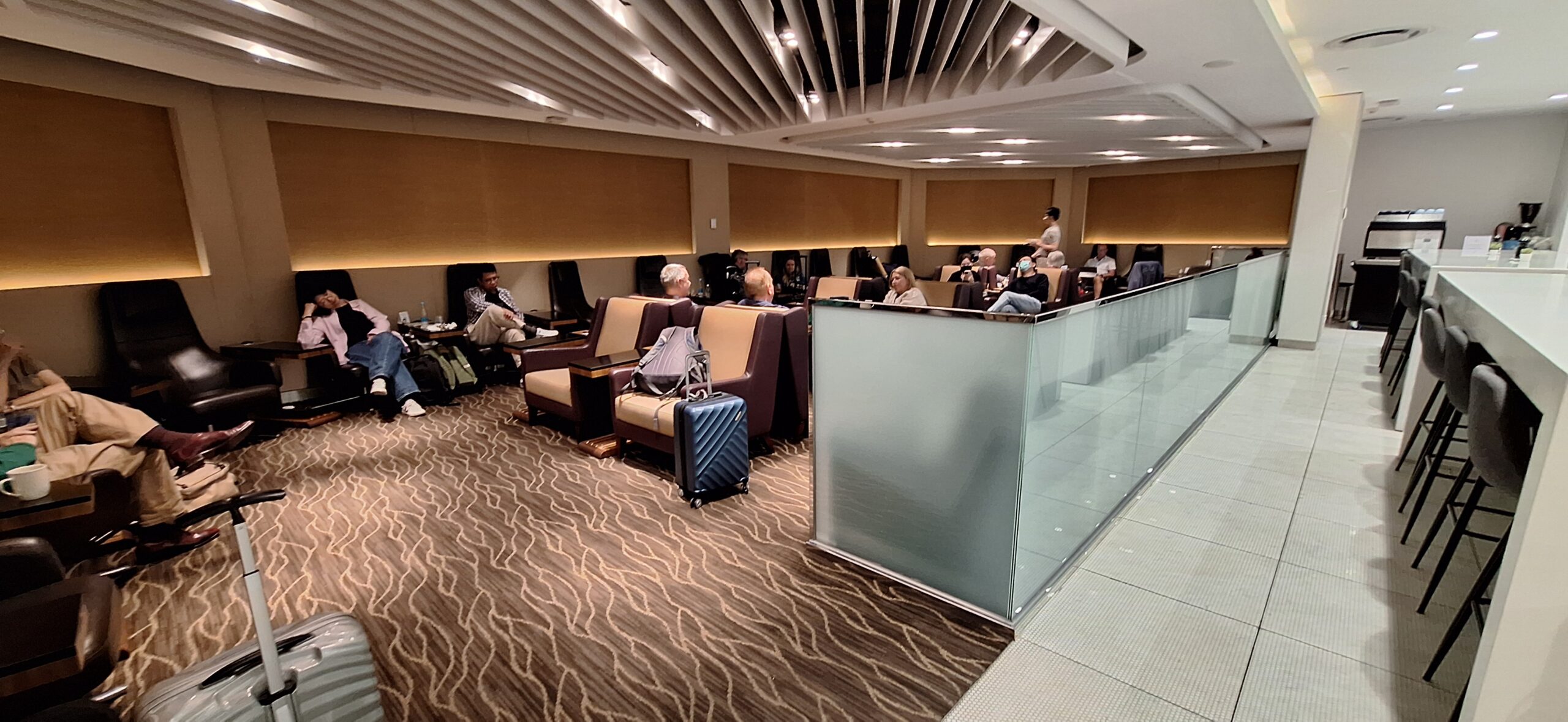 a group of people sitting in a room with chairs and luggage