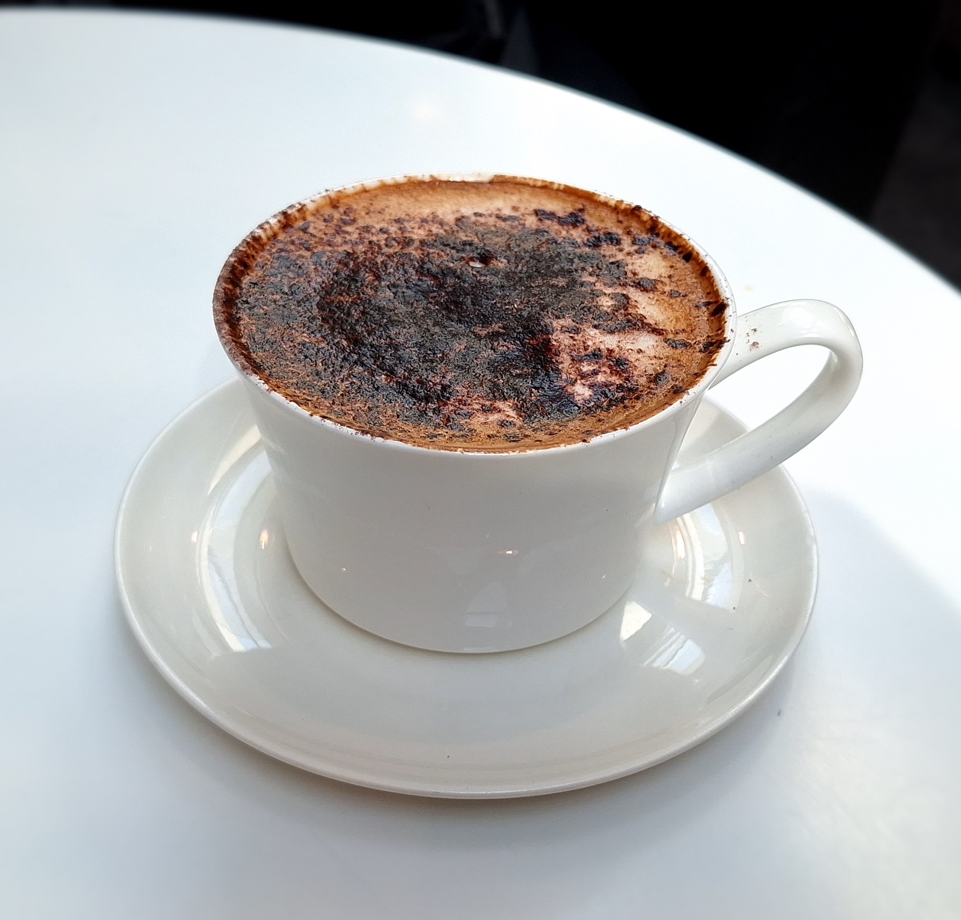 a cup of coffee on a white table