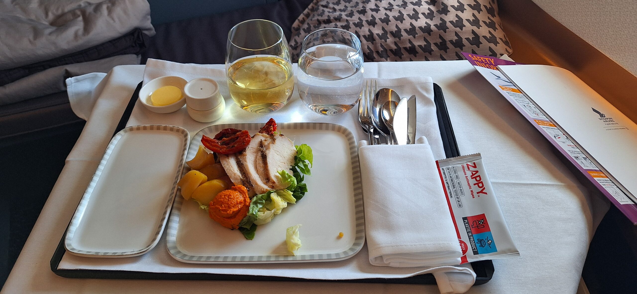 a plate of food and glasses of water on a tray