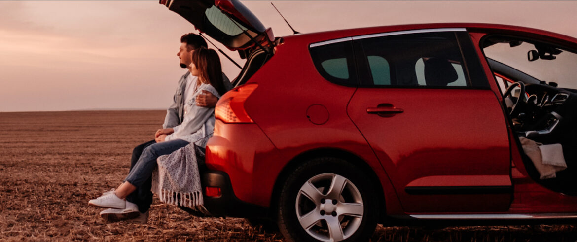a group of people sitting in the back of a red car