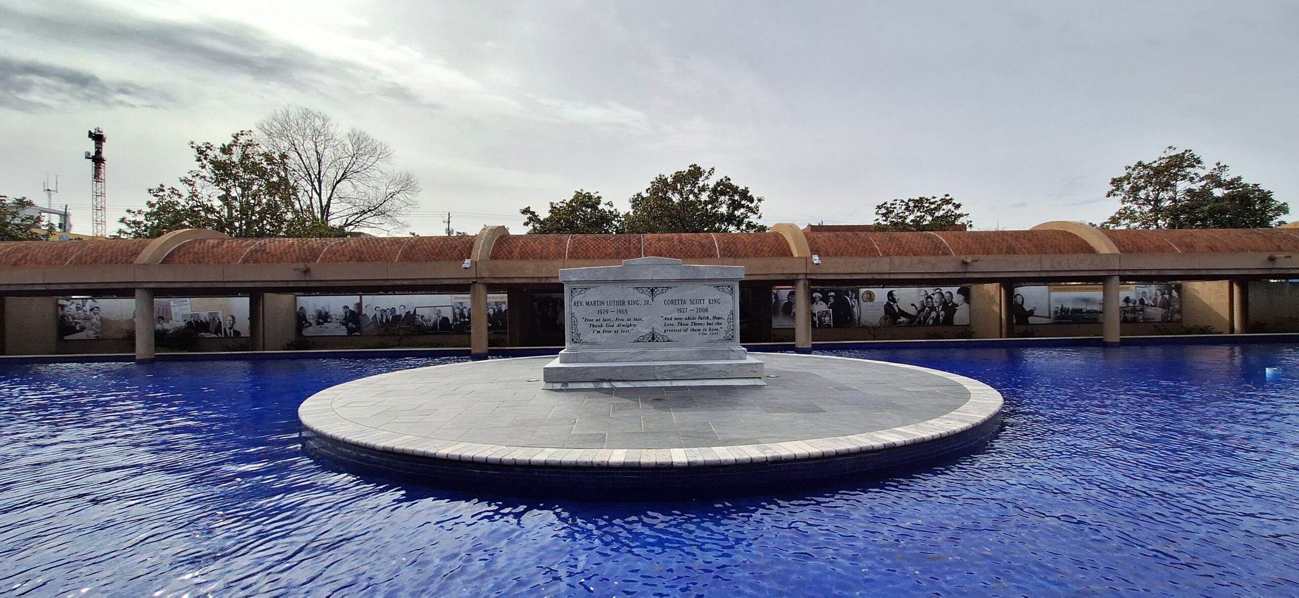 a large white stone monument in a circular pool with blue water