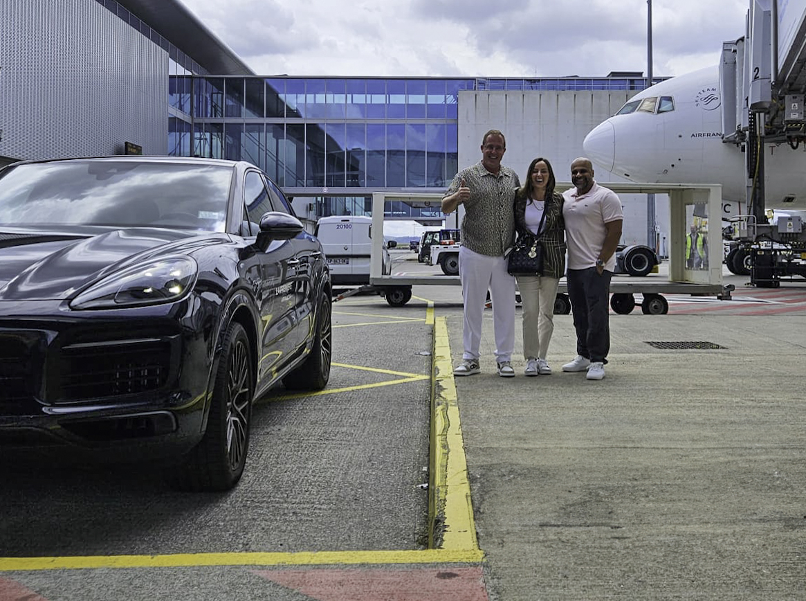 a group of people standing in front of a car