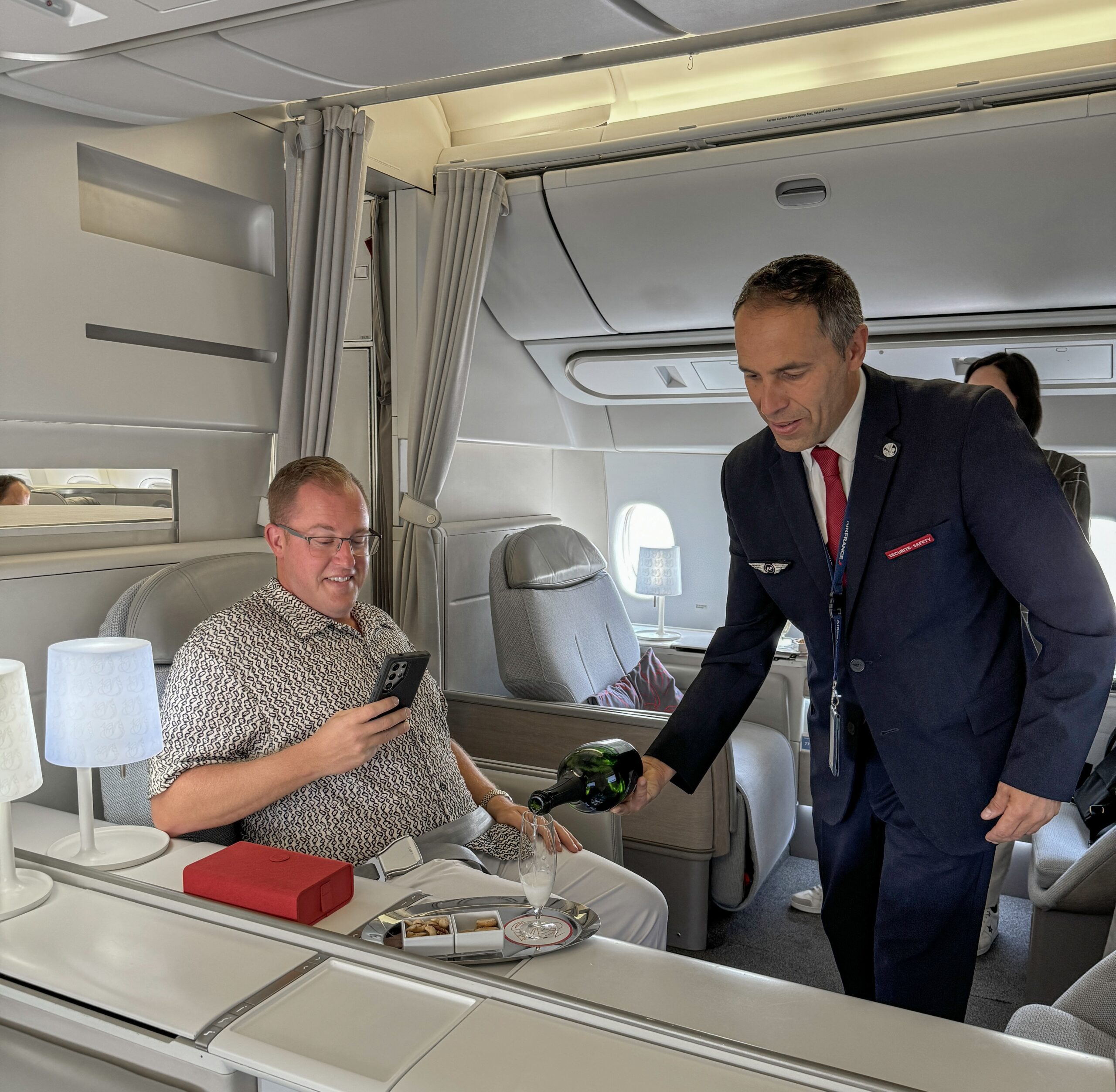 a man pouring a bottle of wine into a man's hand