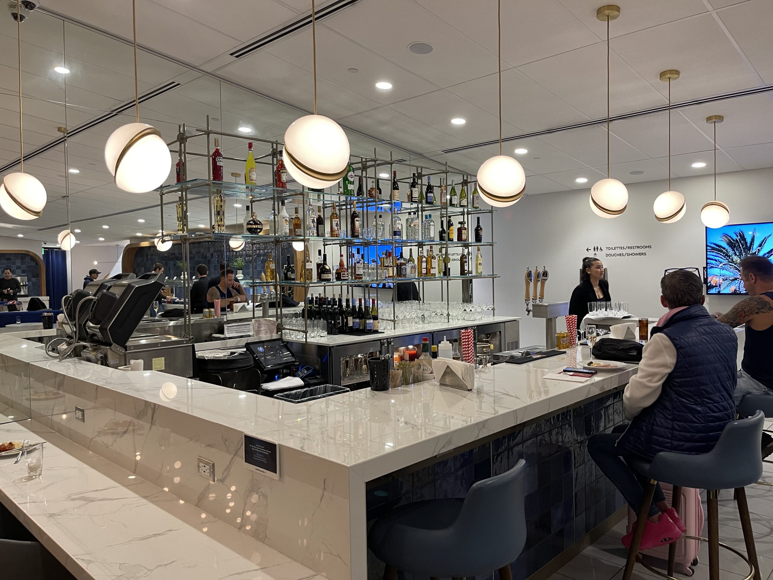 a bar with a counter and a couple of people in the background