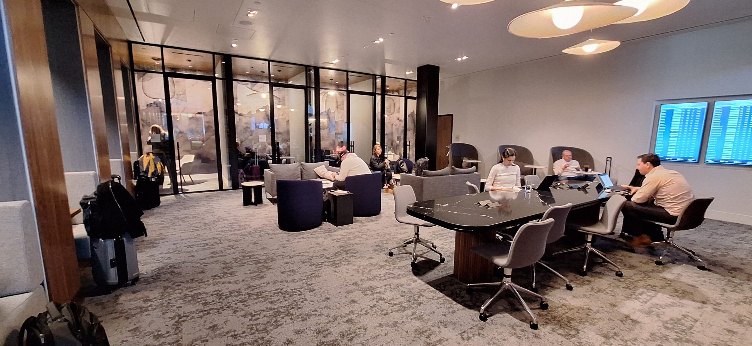 a group of people sitting around a table in a room with glass walls