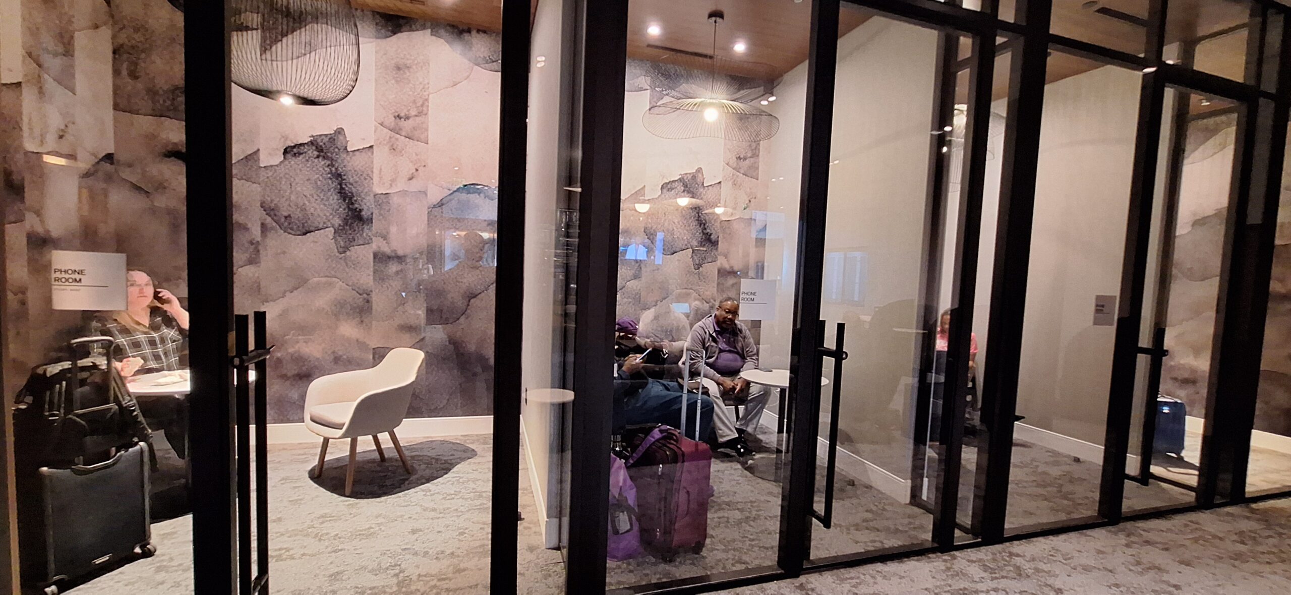 a group of people sitting in a room with luggage