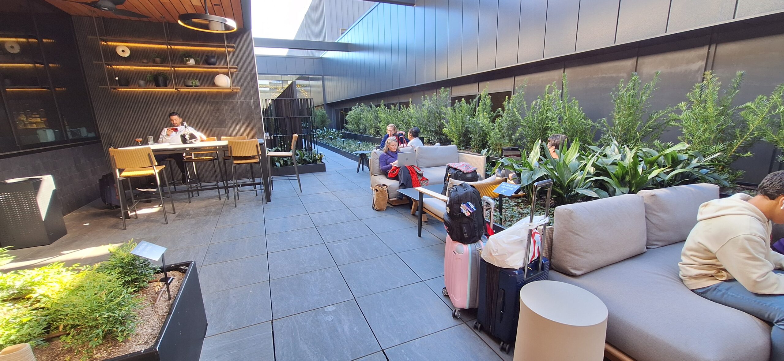 a group of people sitting on chairs and a table with luggage