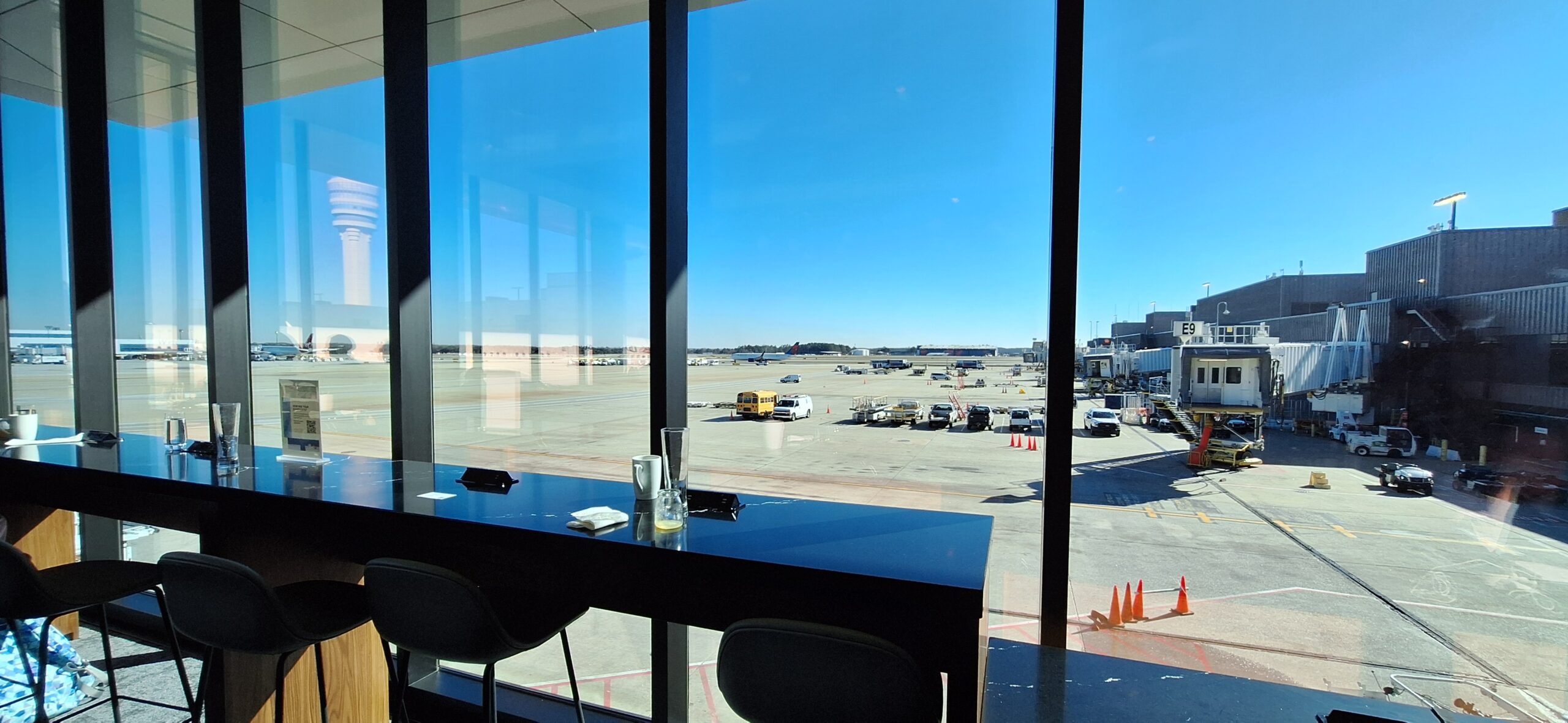 a table with chairs and a glass window with a view of an airport