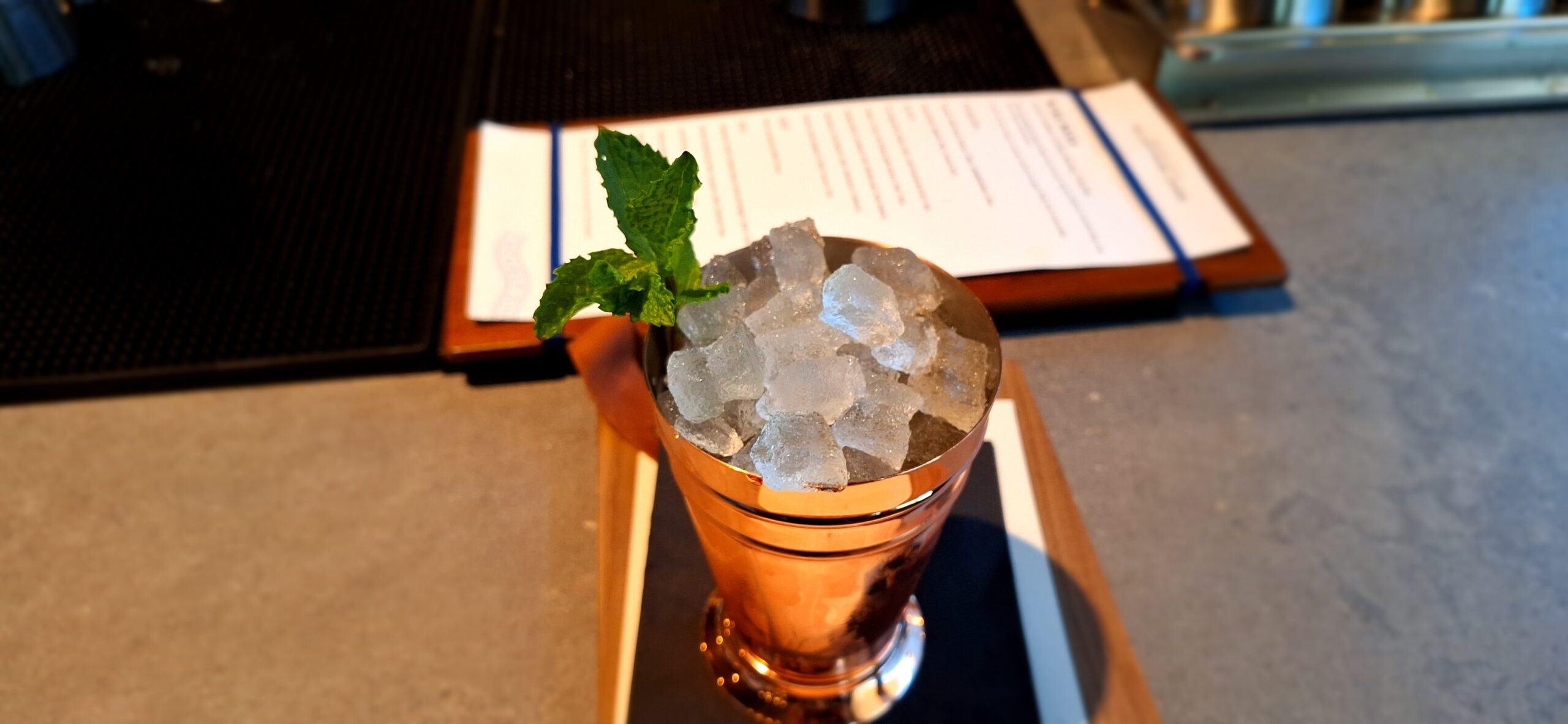 a copper cup with ice cubes and mint leaf