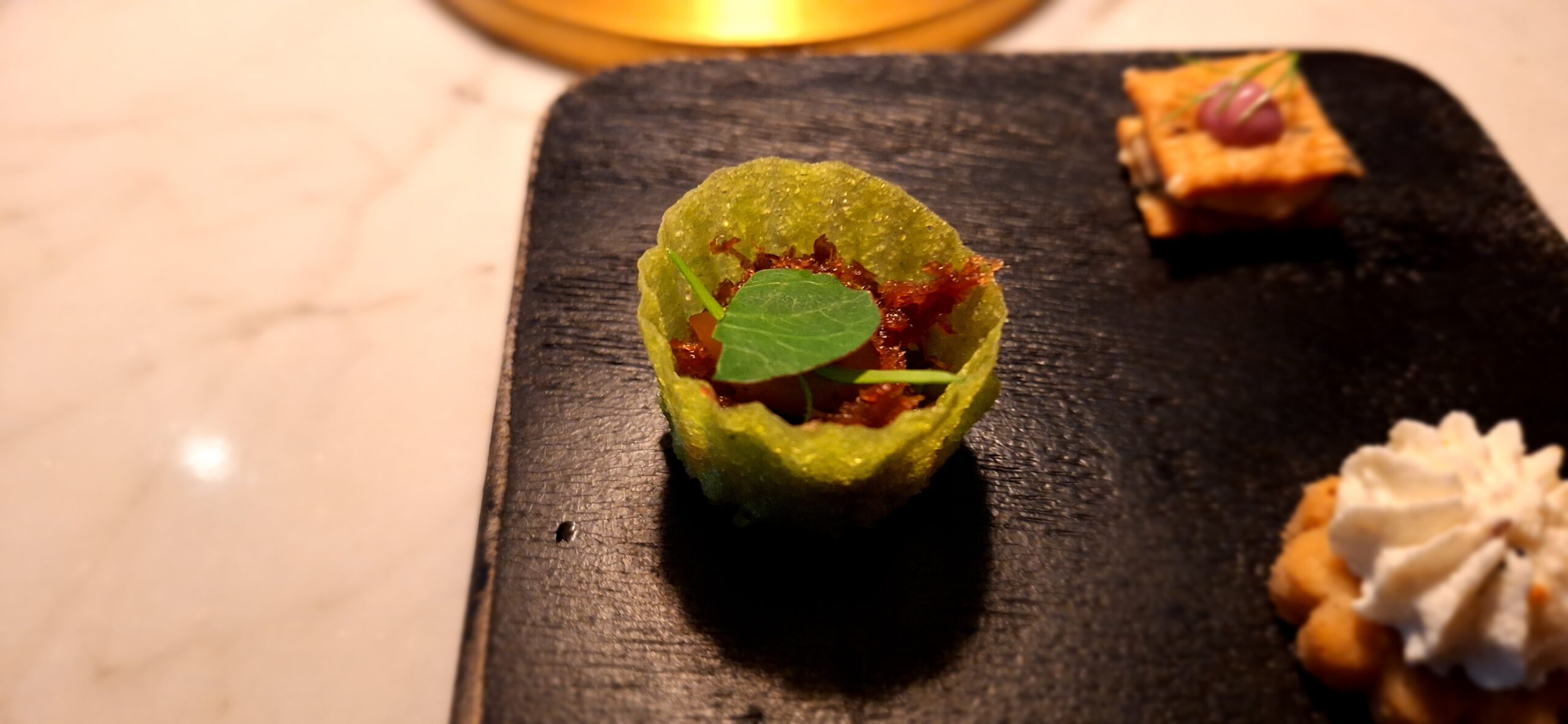 a small green food item on a black surface