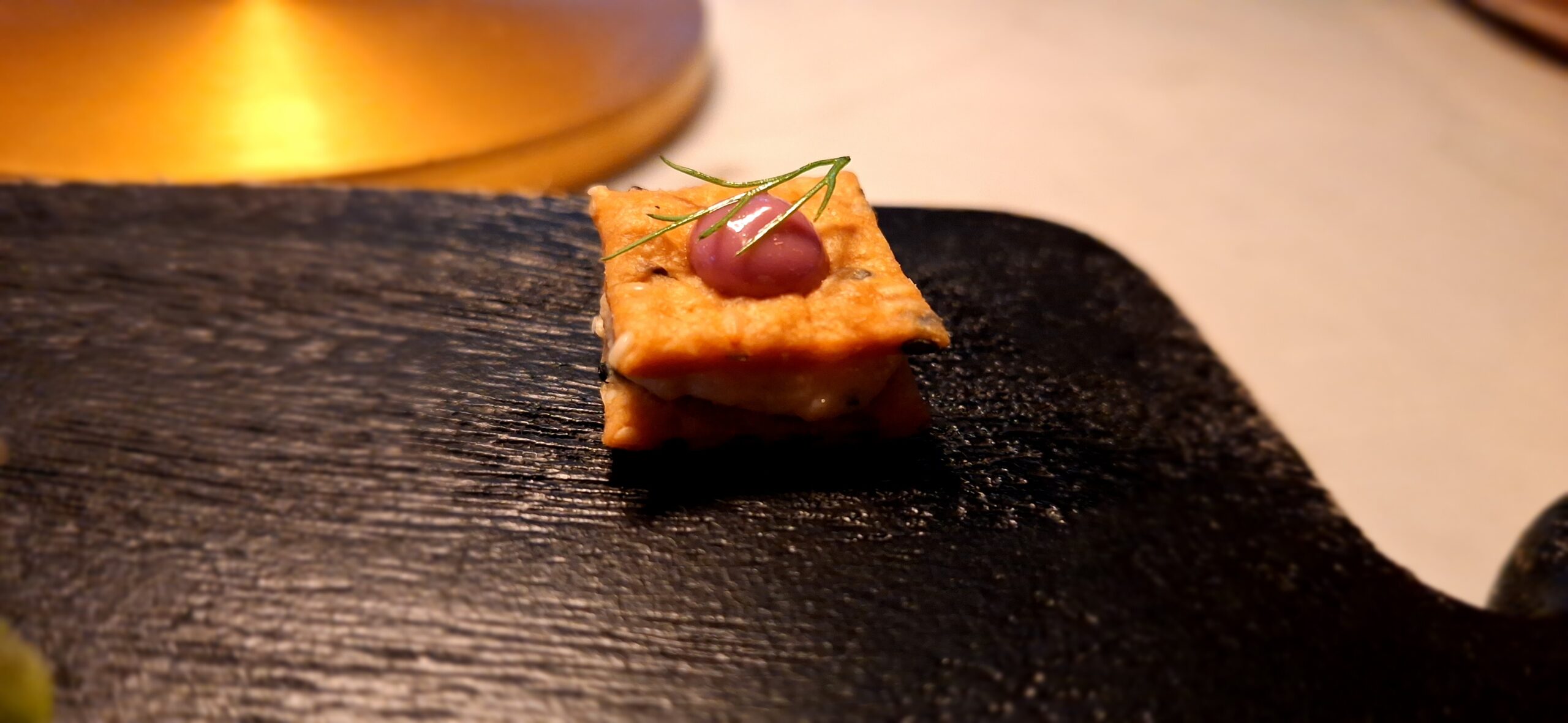 a small square food item on a black surface