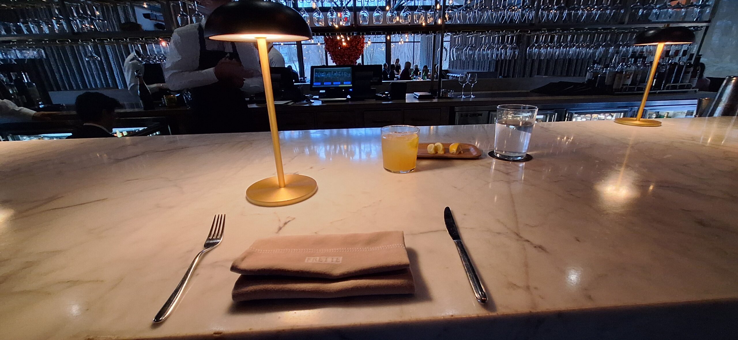 a table with a lamp and a napkin and a fork