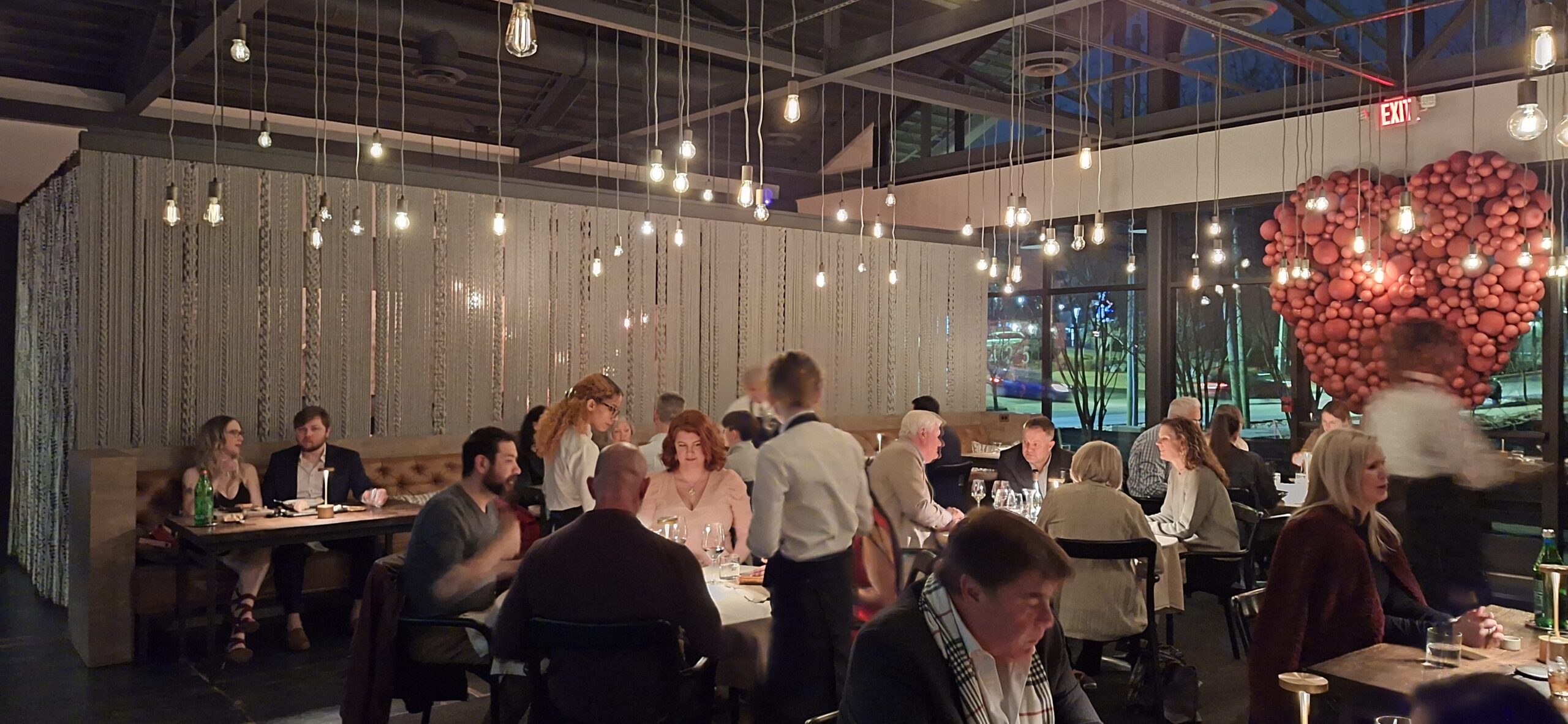 a group of people sitting at tables in a restaurant