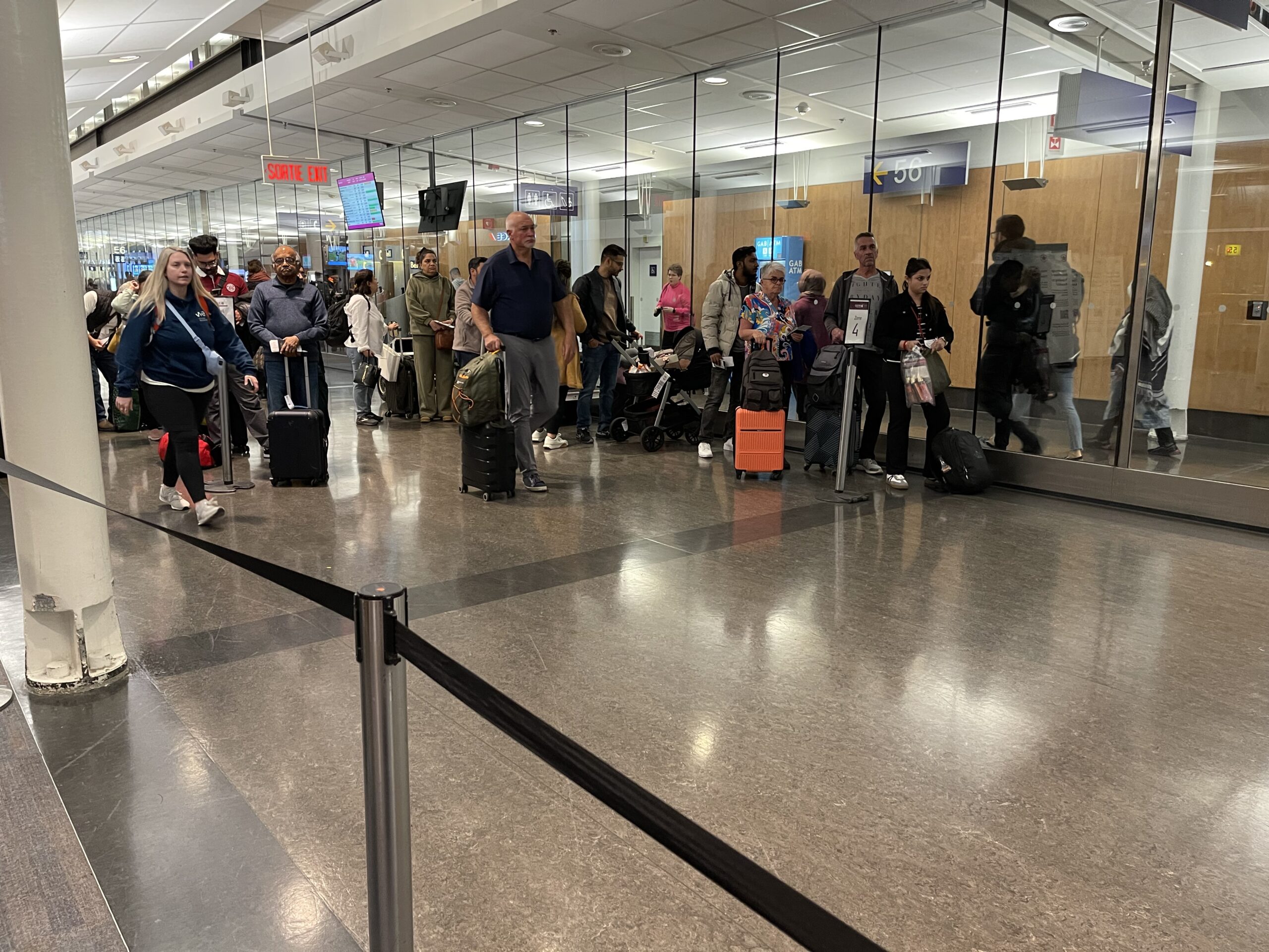 a group of people standing in a line in a terminal