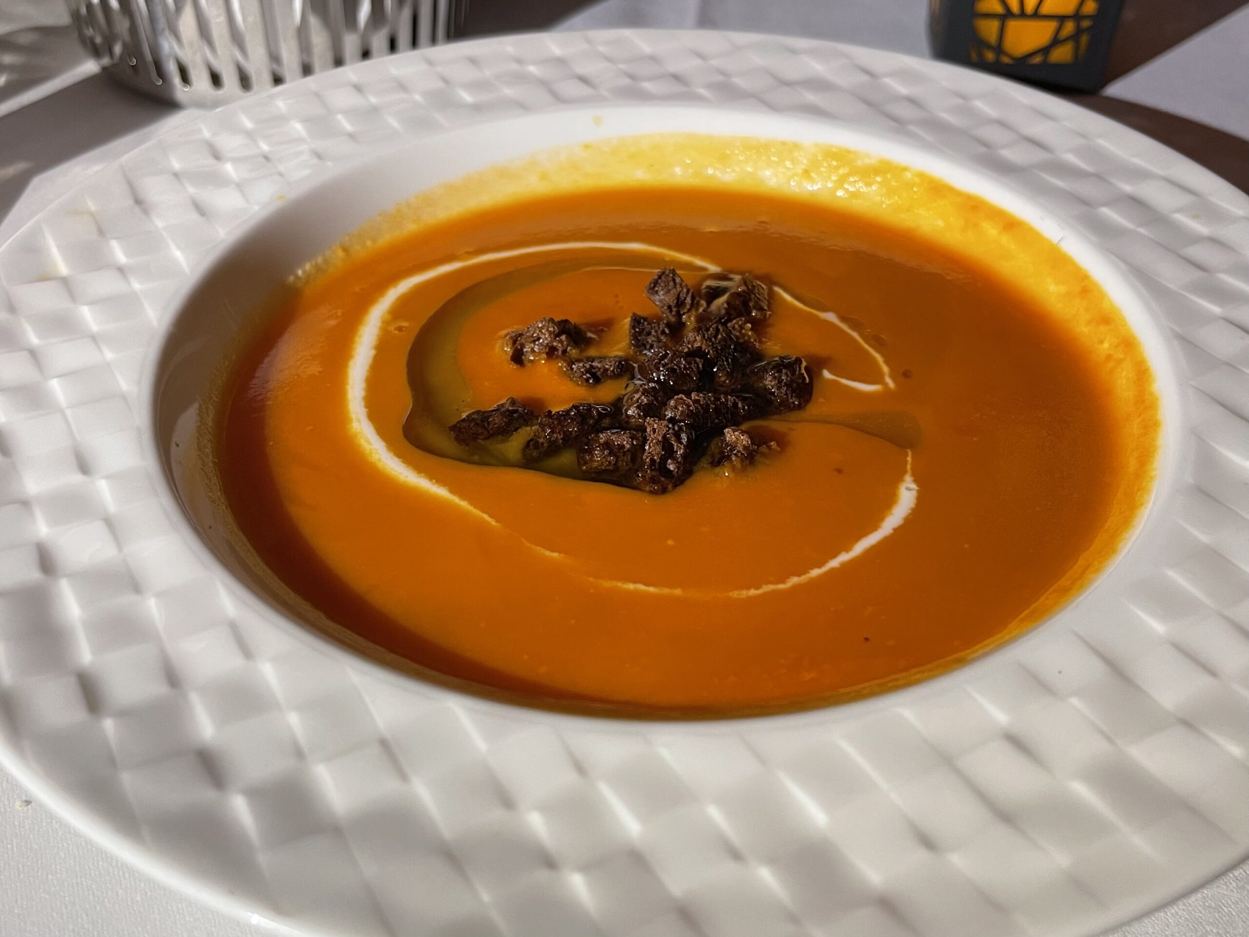 a bowl of soup with brown food on top