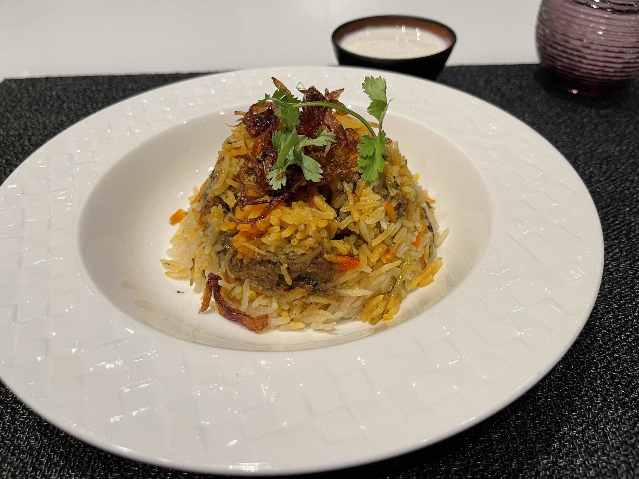 a plate of rice with meat and cilantro