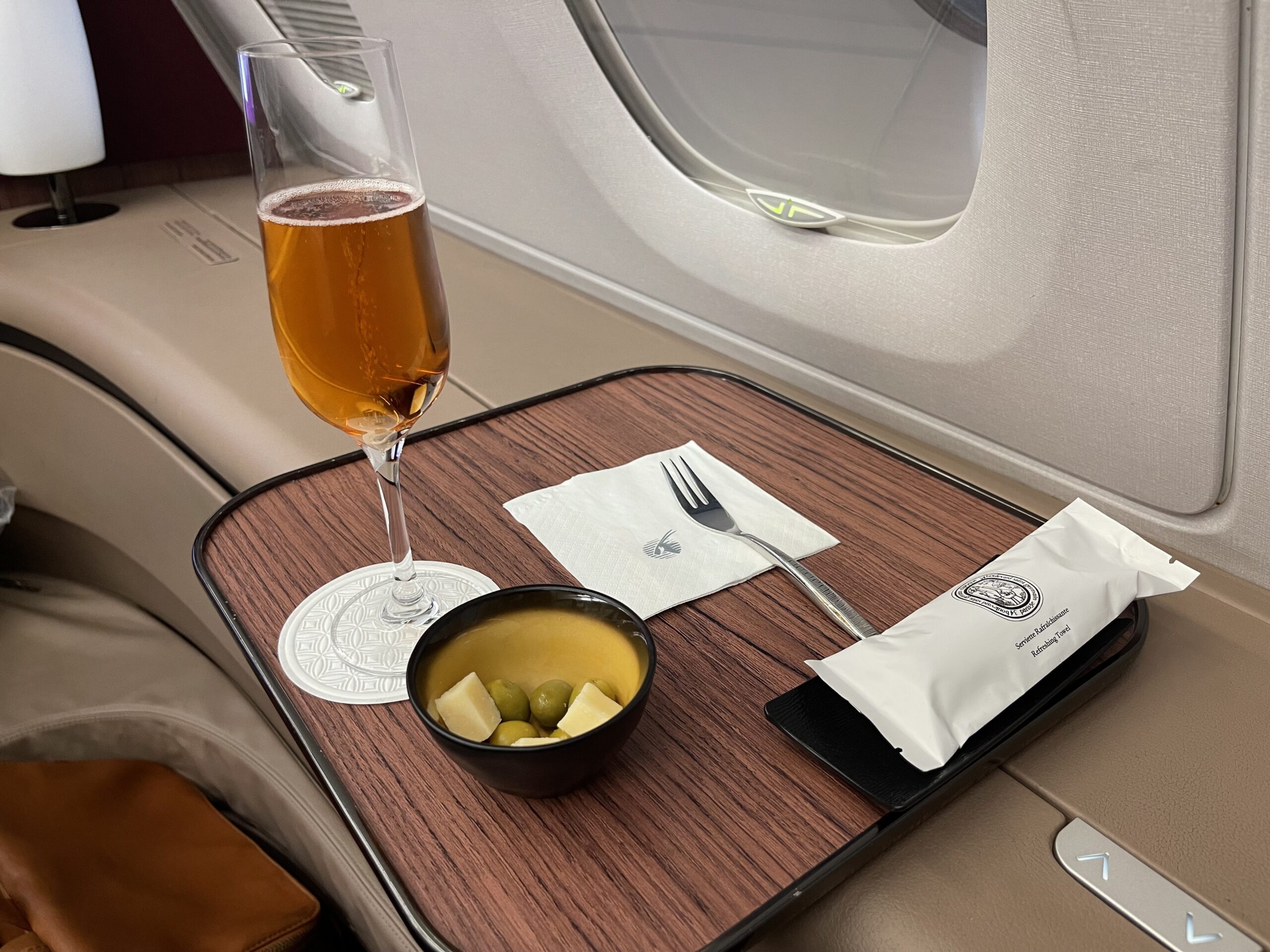 a glass of beer and a bowl of food on a tray