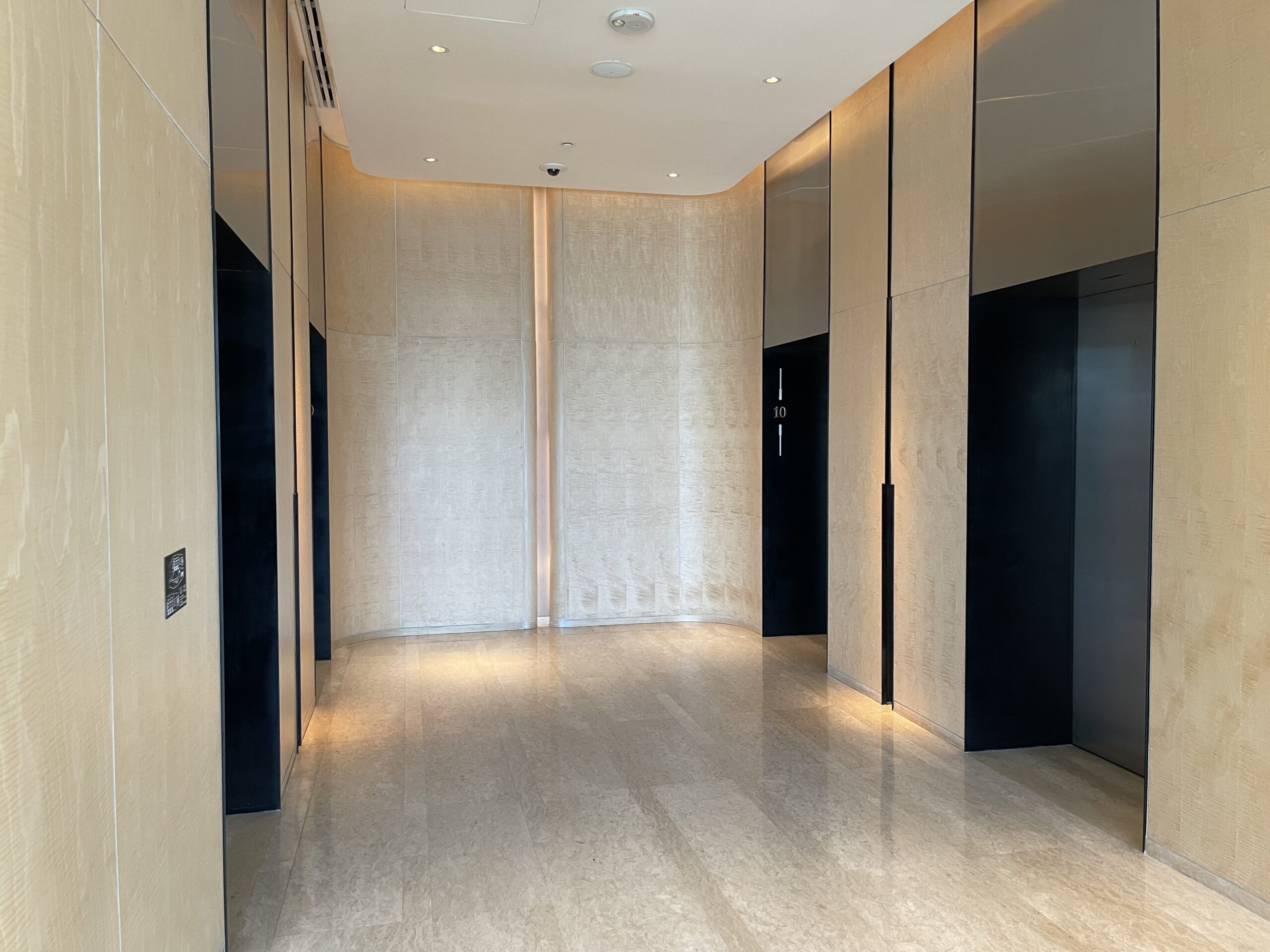 a hallway with black doors and a marble floor