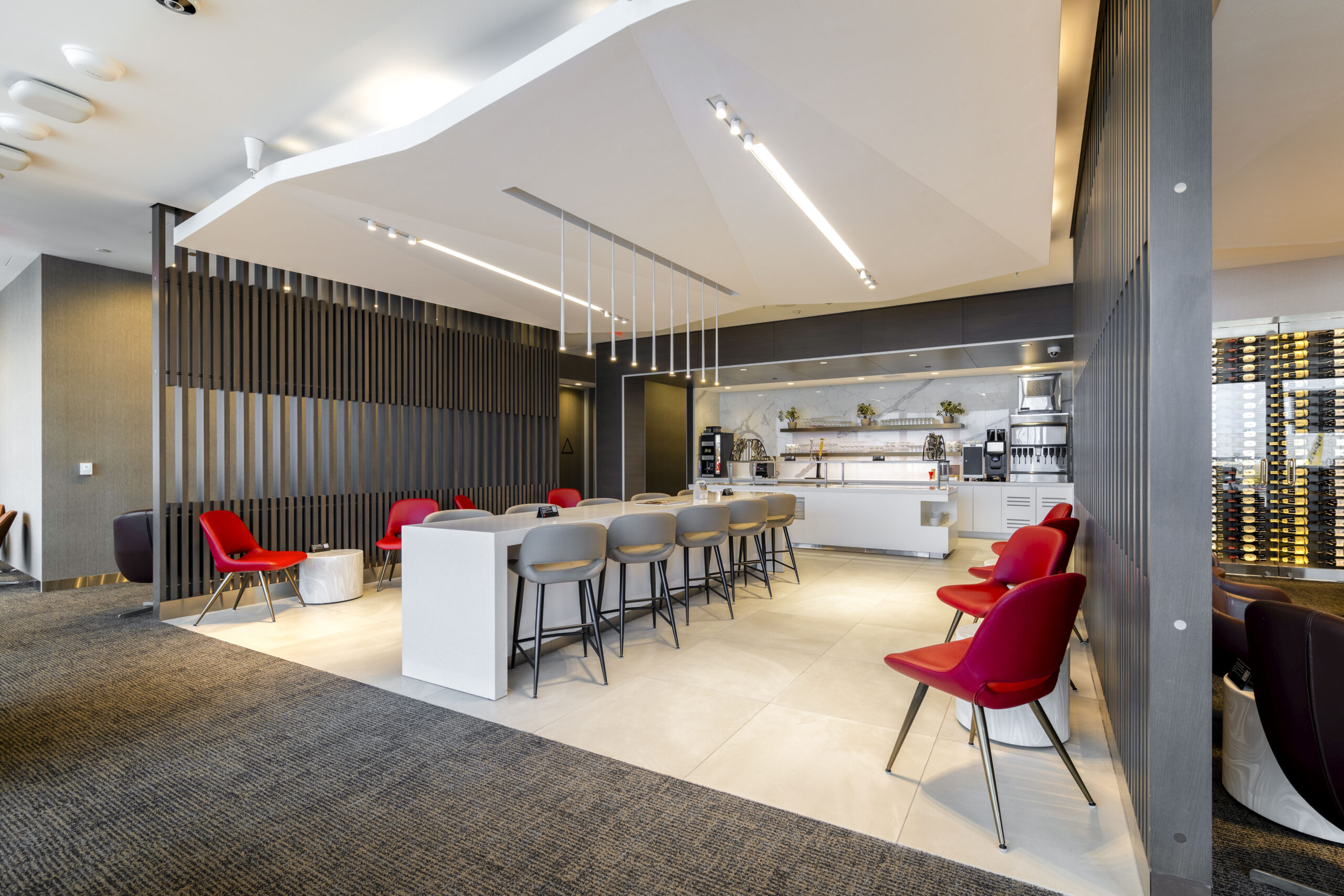 a room with a white counter and red chairs