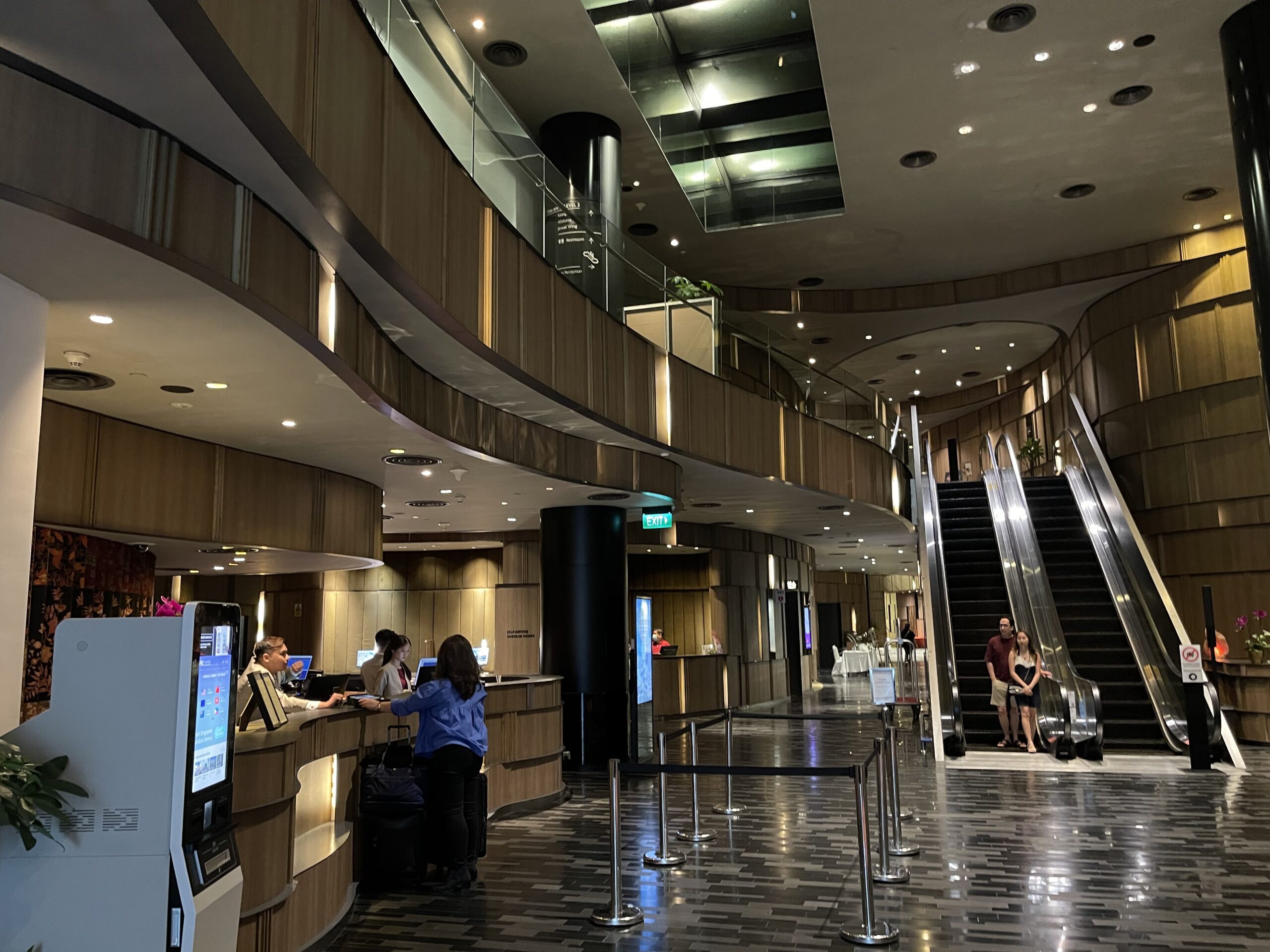 a lobby with a staircase and people standing in front of it