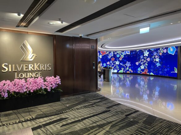 a lobby with a sign and flowers