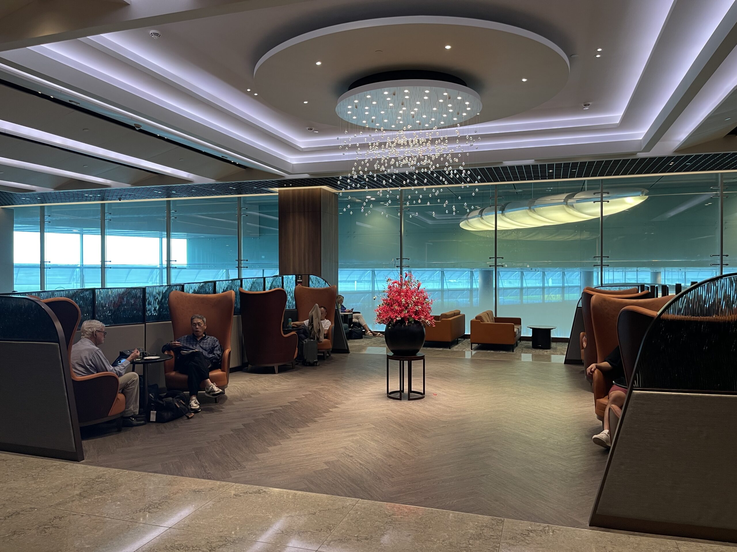 a group of people sitting in a room with a chandelier