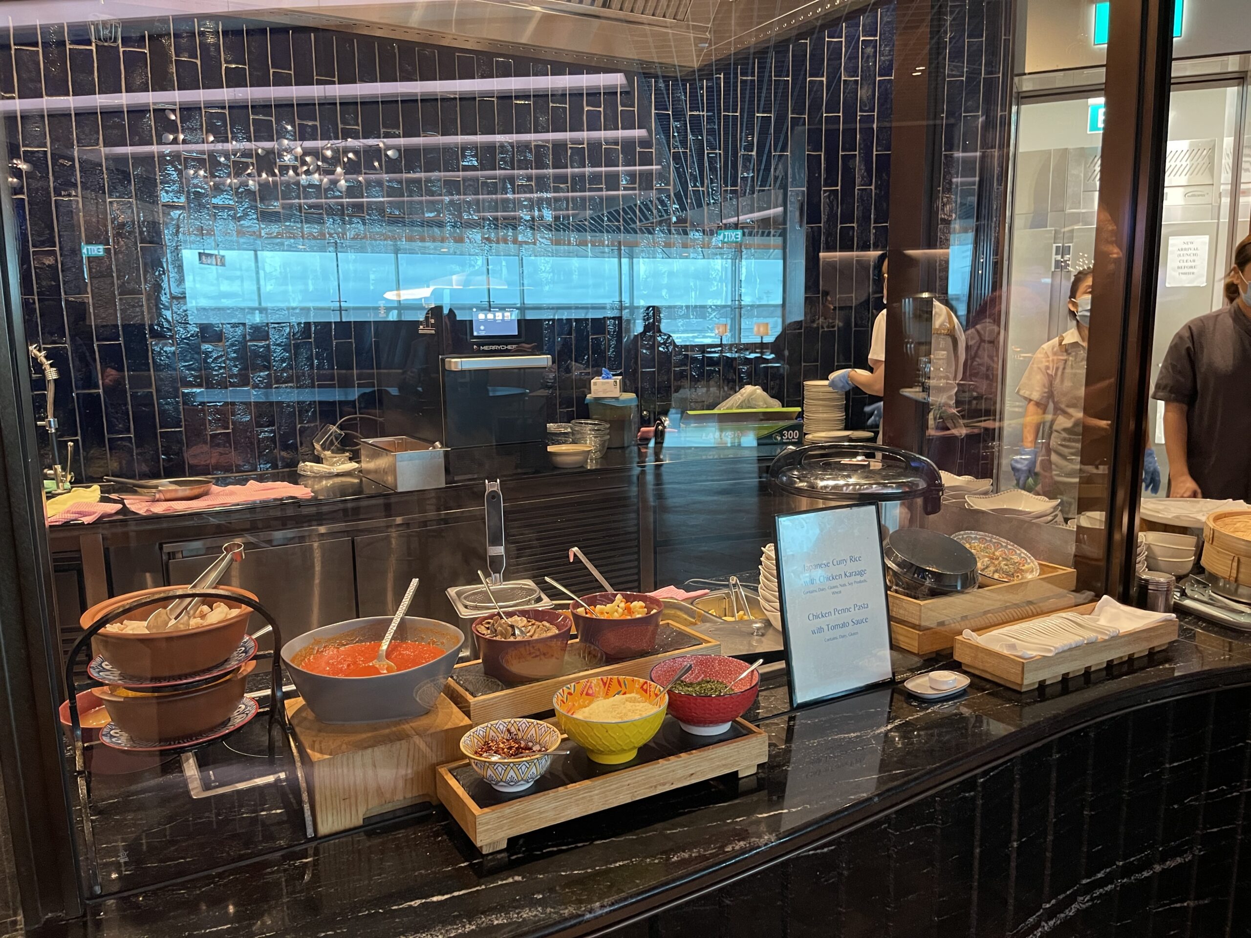 a food buffet with a person standing behind it