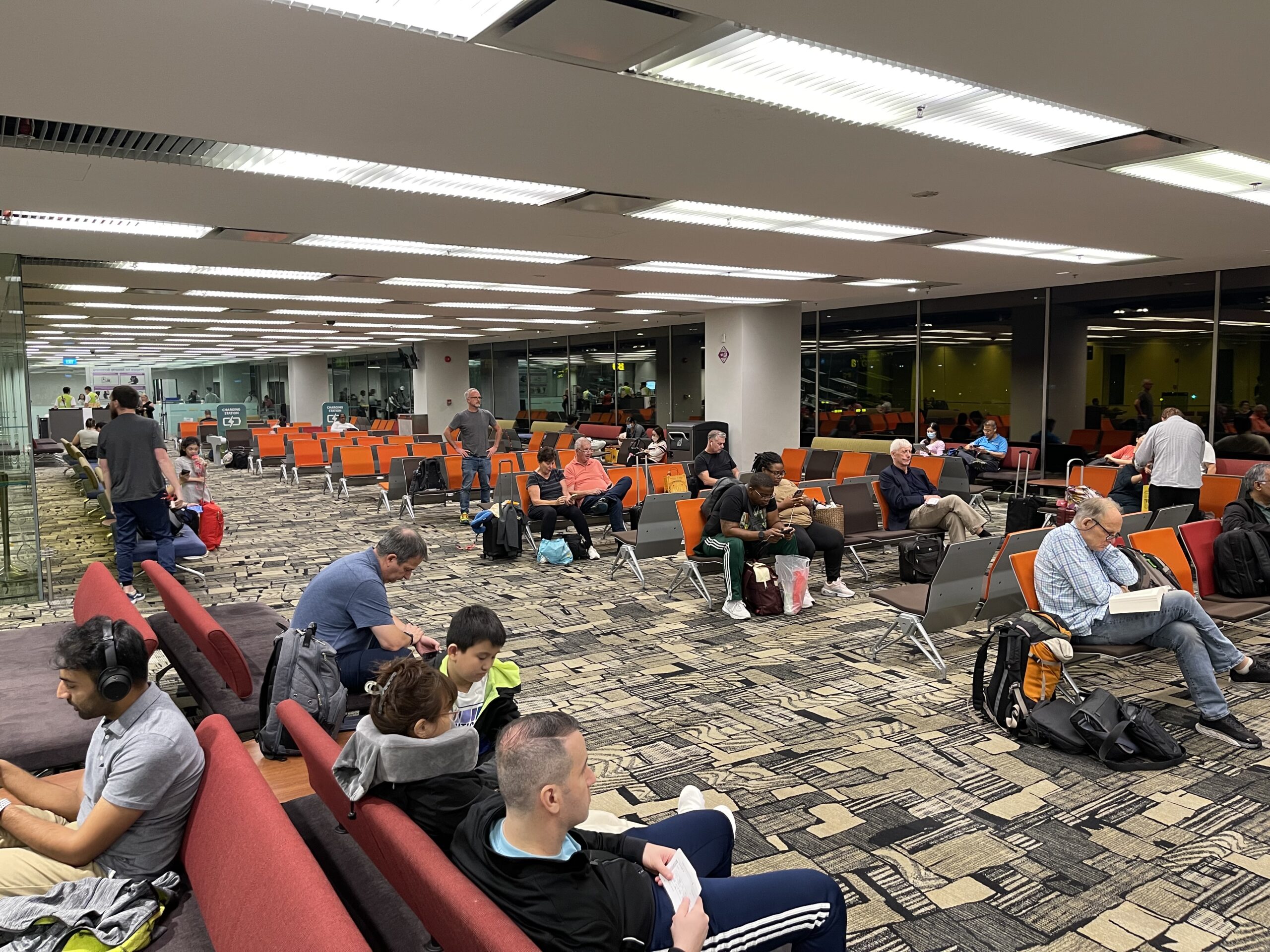 a group of people sitting in an airport lounge