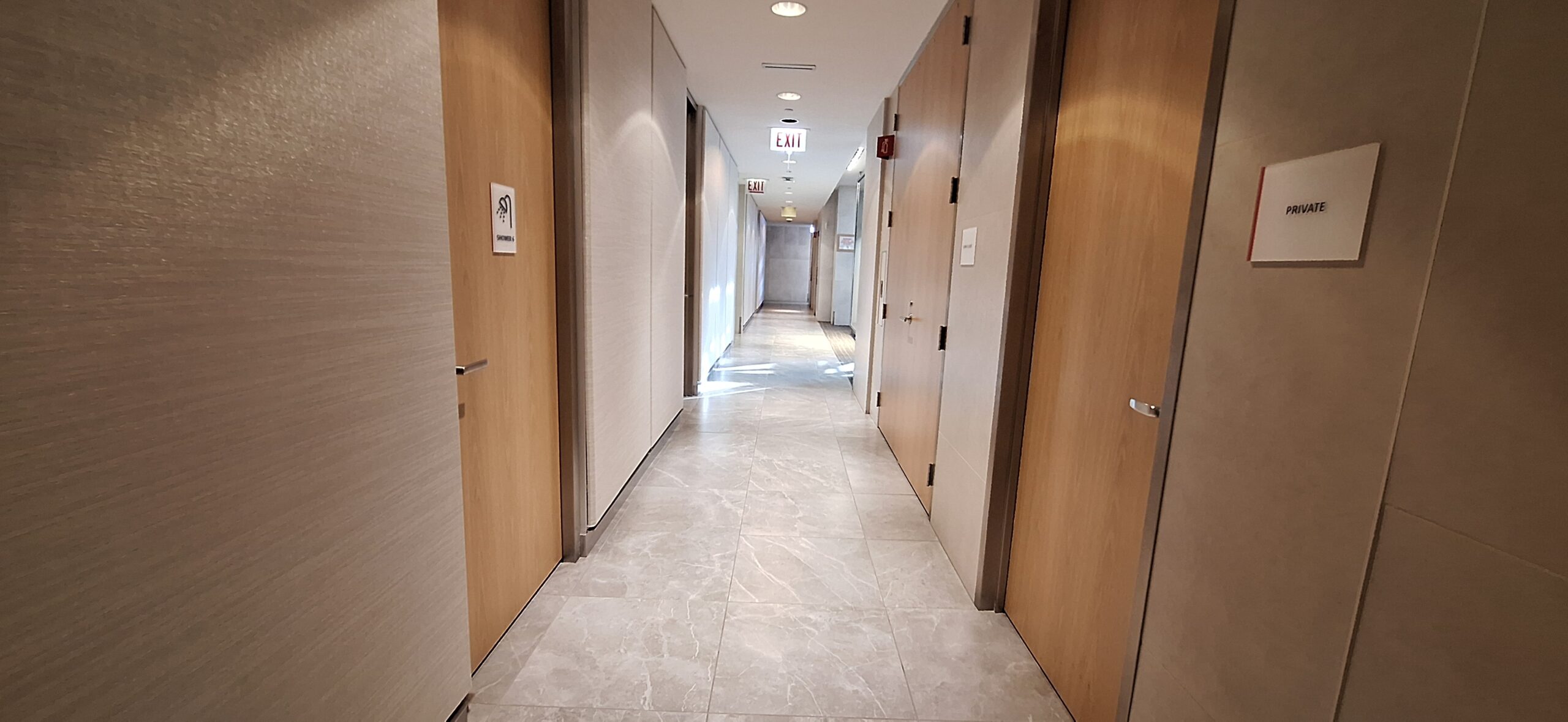 a hallway with doors and a light shining on the ceiling