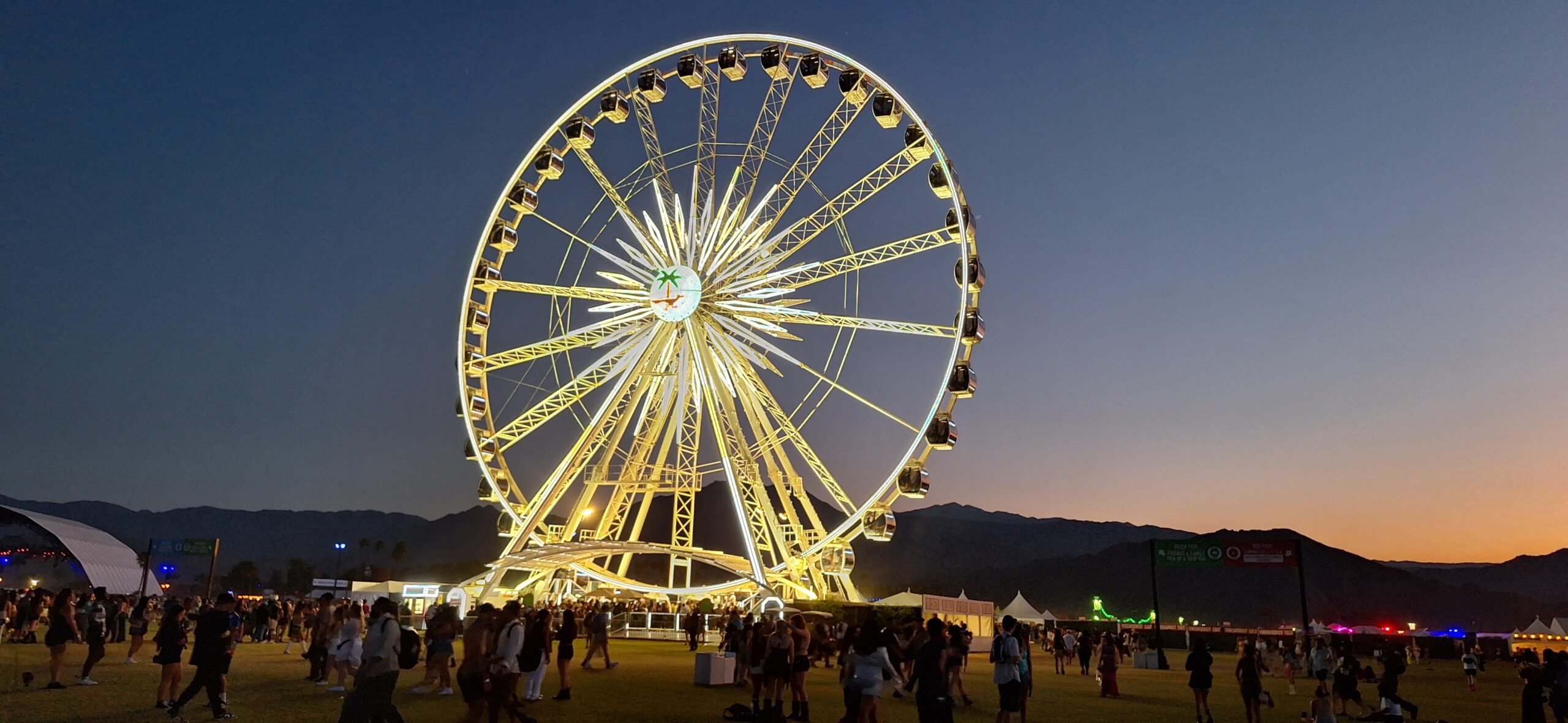 a ferris wheel lit up at night with Brighton Wheel in the background