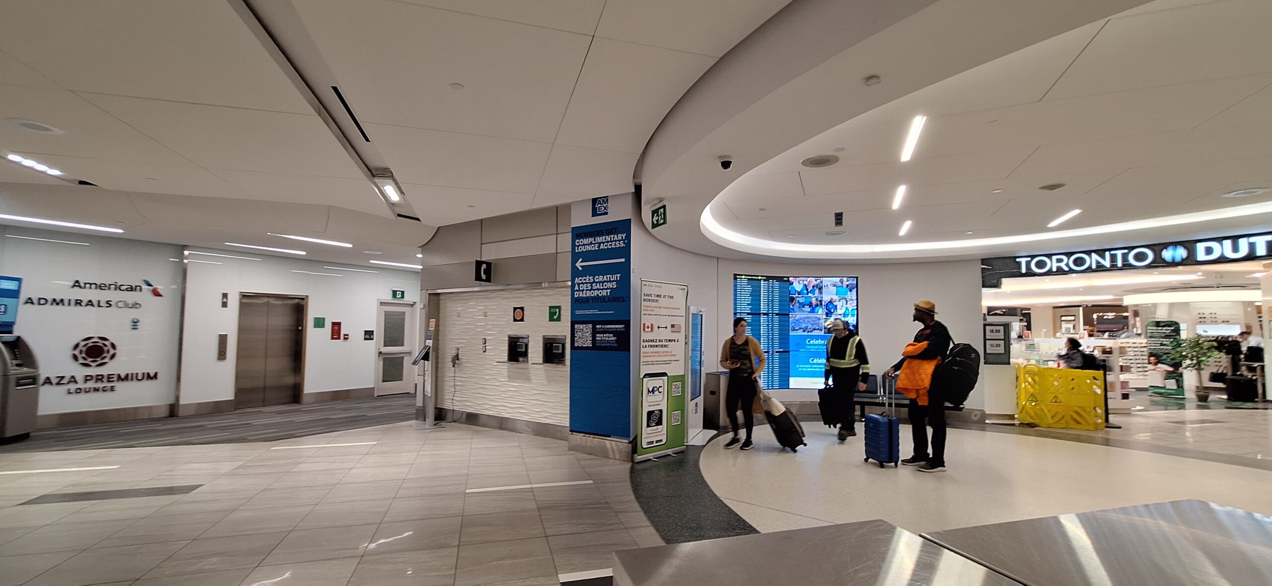 people in a building with a sign and people with luggage