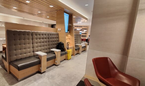 a room with a large bench and chairs