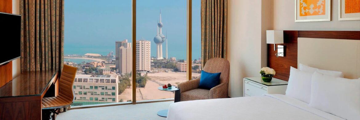 a room with a bed and a chair and a table with a window