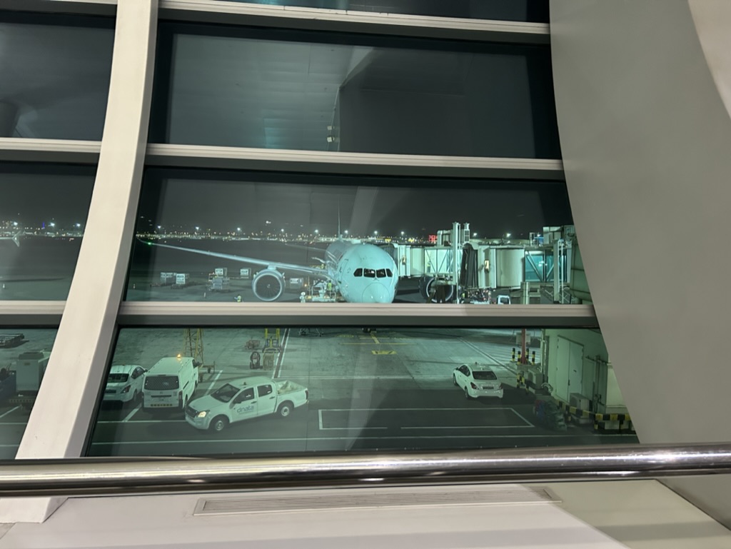 a window with a plane and cars in the airport