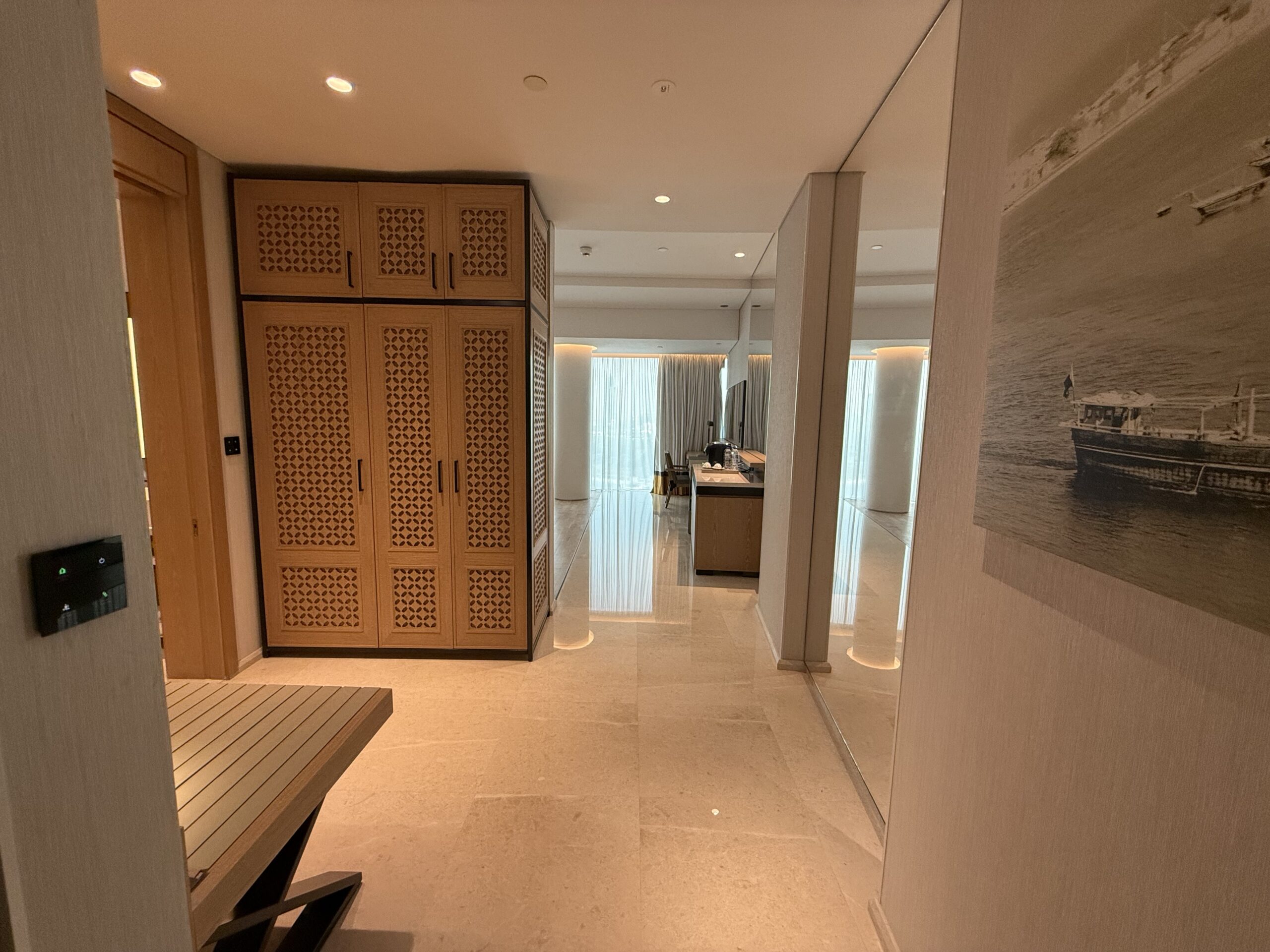 a hallway with a mirror and a wood cabinet