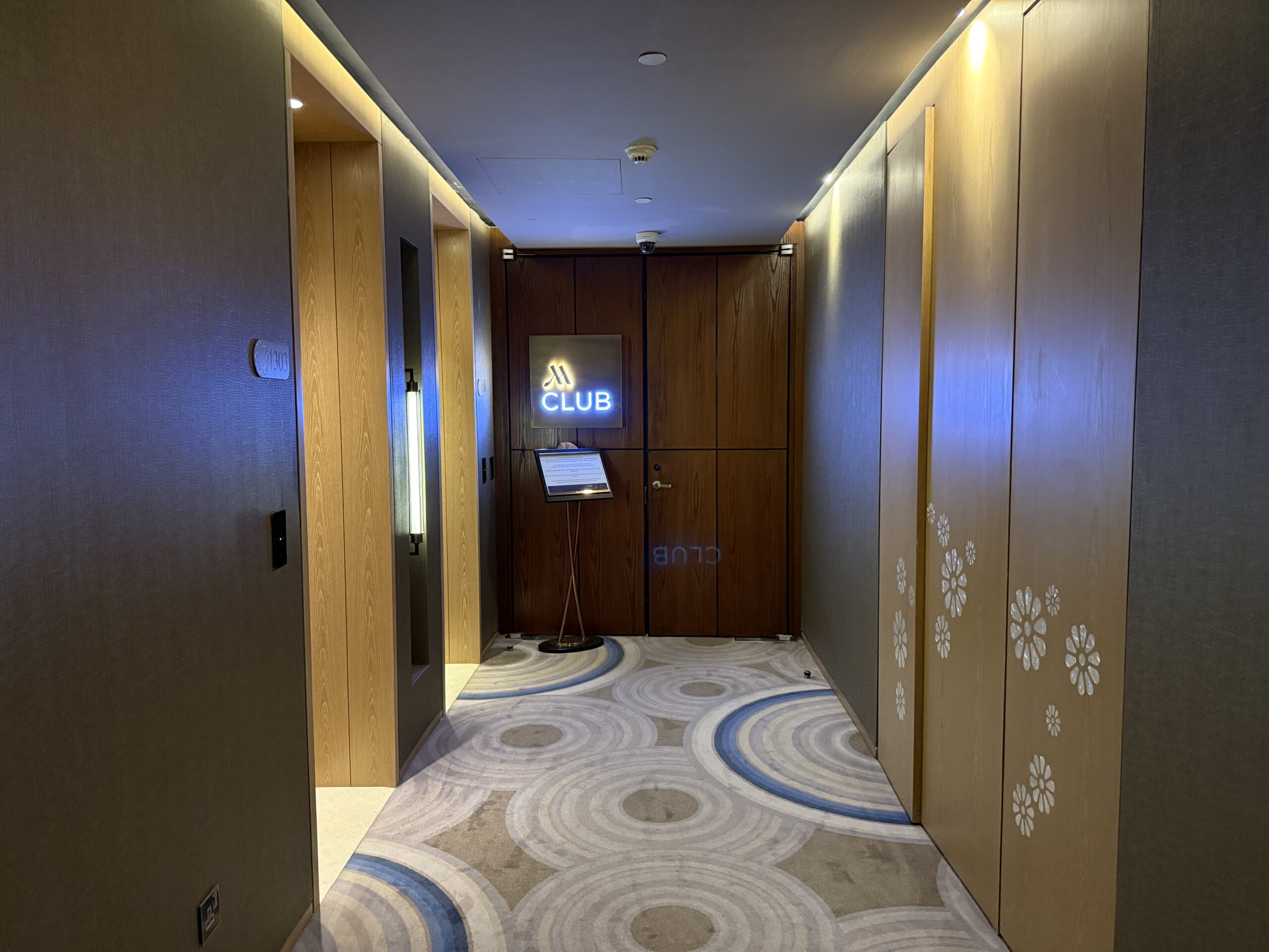 a hallway with wood doors and a sign