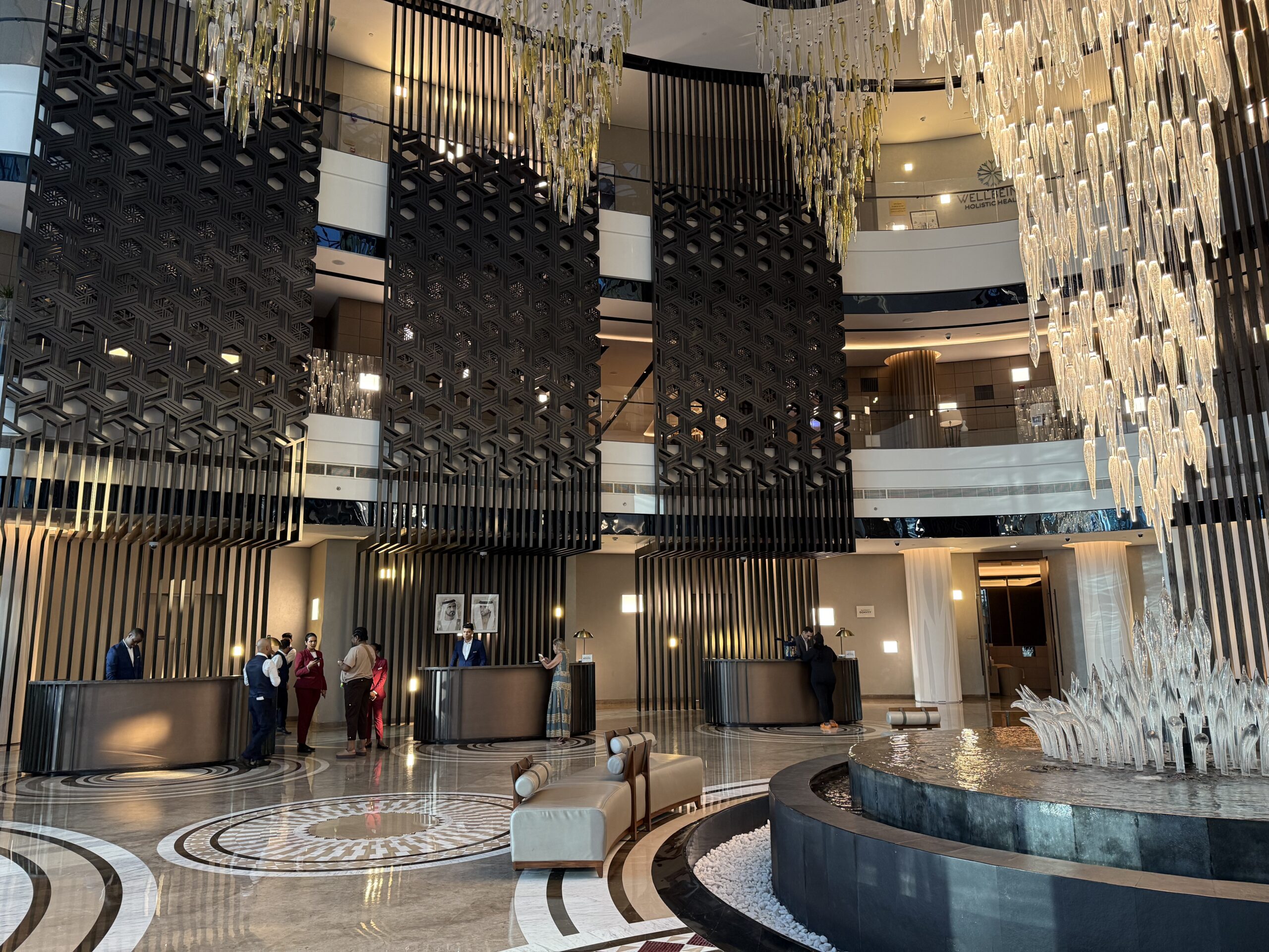 a lobby with a fountain and chandeliers