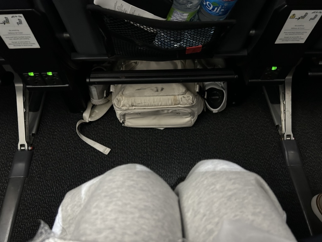 a person's legs and a bag on the floor