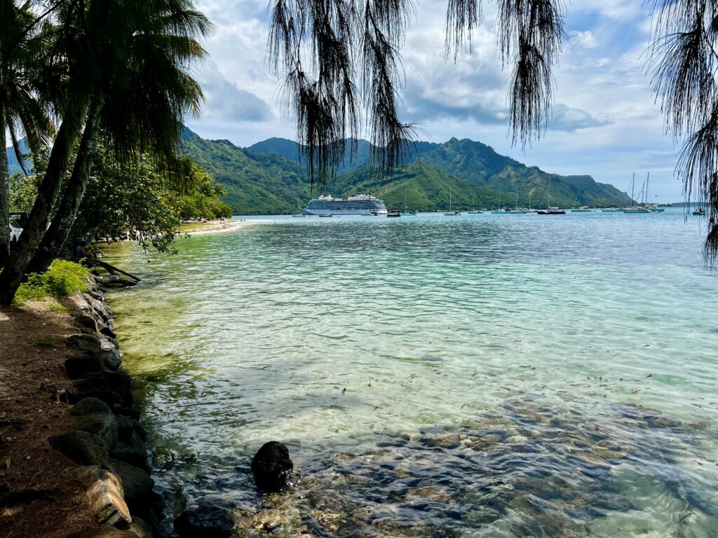 a body of water with trees and mountains in the background French Polynesia