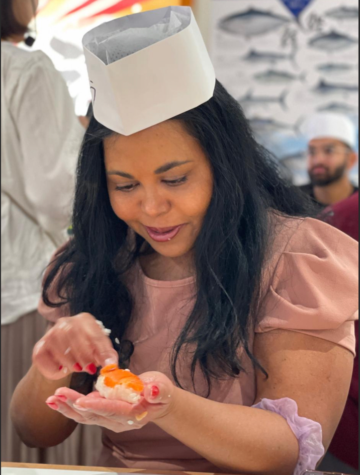 a woman wearing a white hat and holding a piece of food