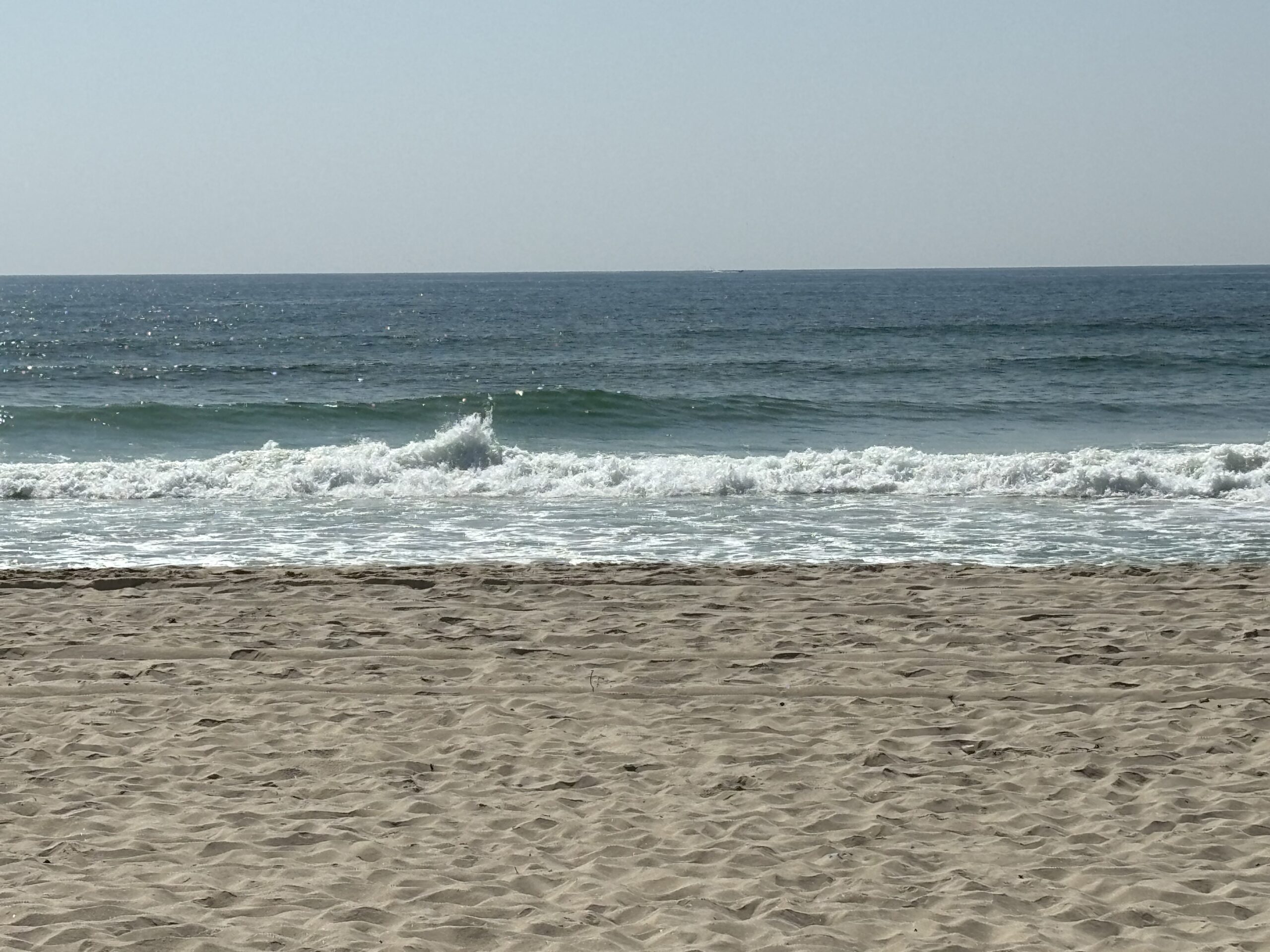 a beach with waves crashing on the shore