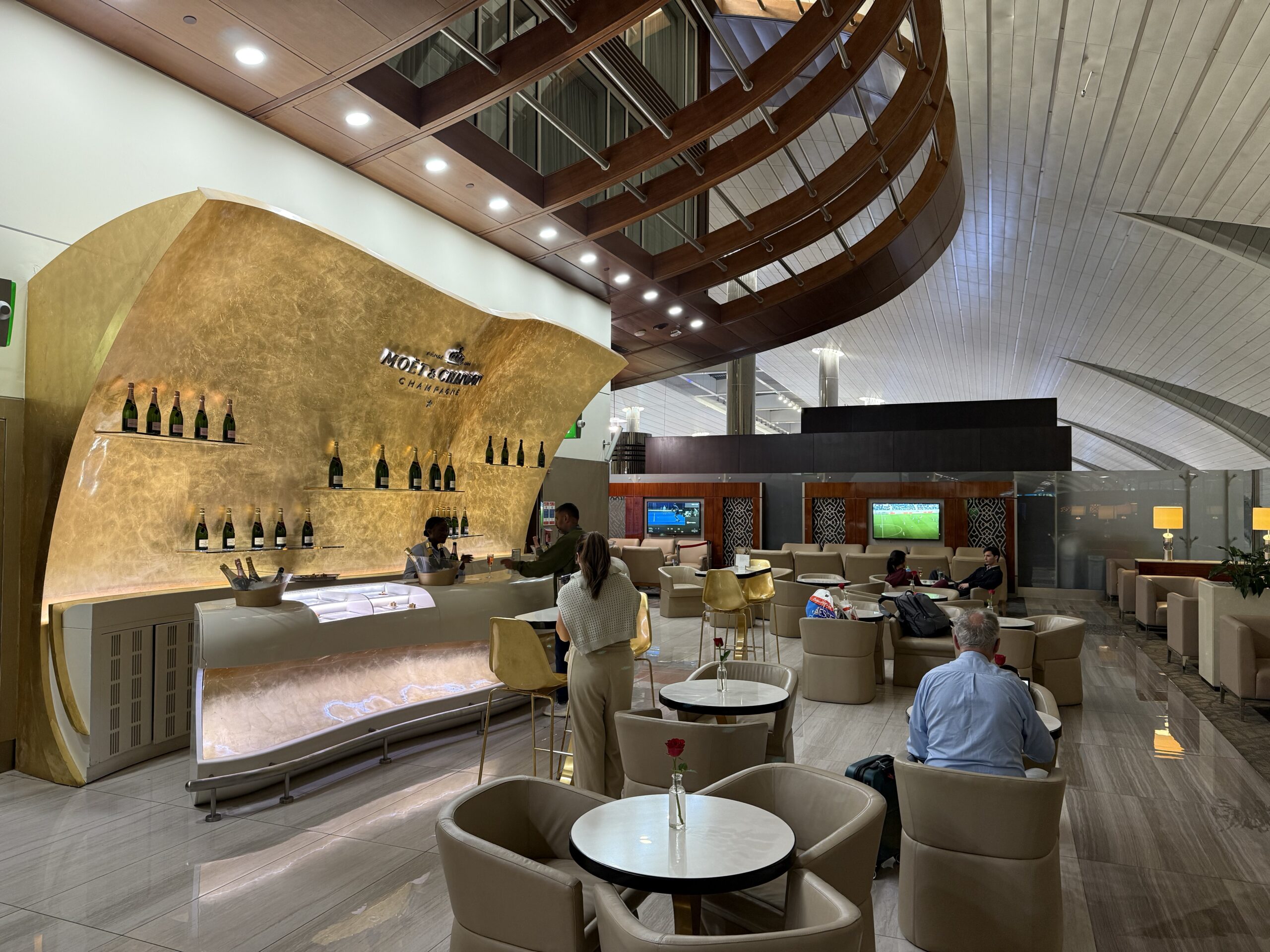 people sitting at tables in a room with a curved ceiling