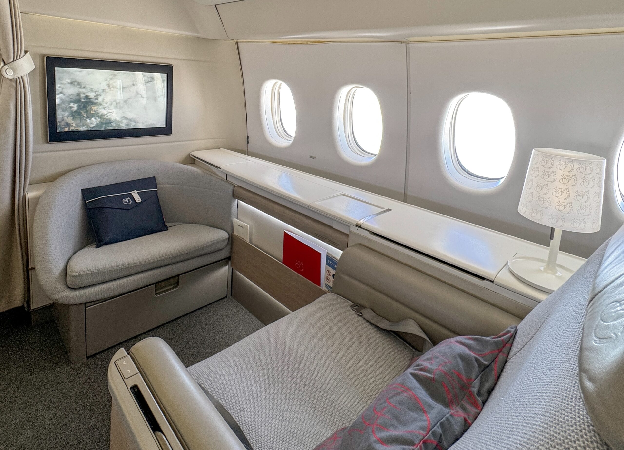 Emirates First and La Premiere a seat and window in an airplane