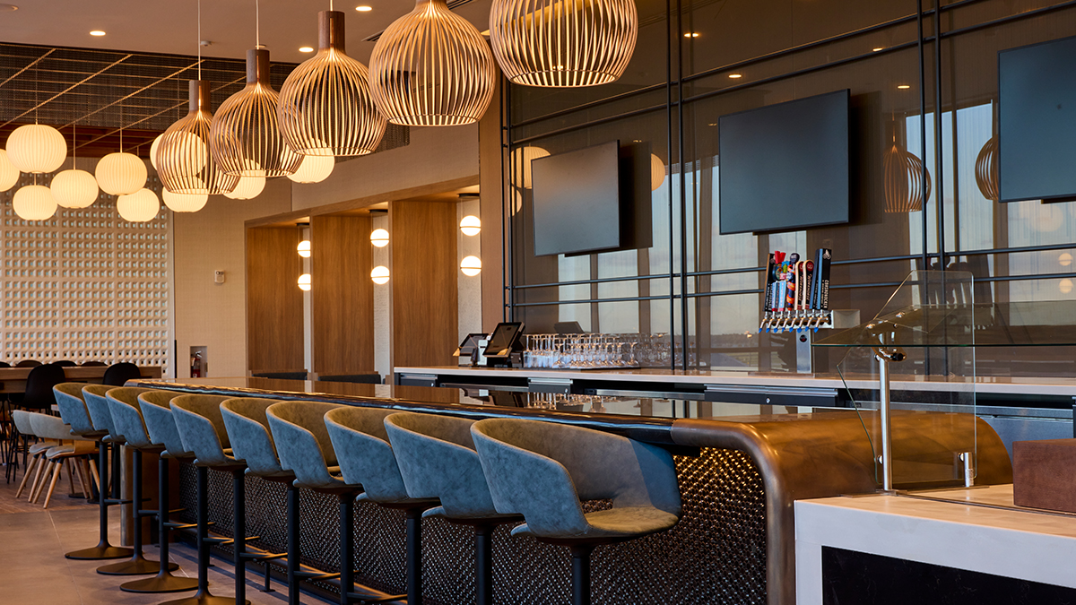 American Flagship Lounge PHL a bar with chairs and a row of lights