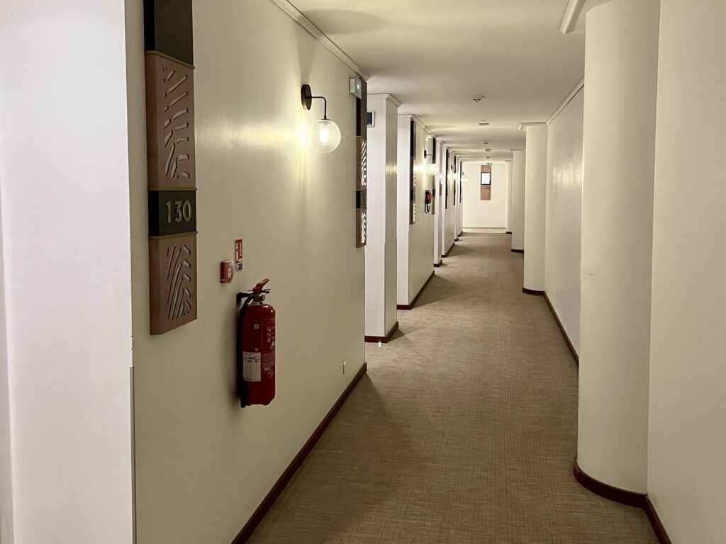 a hallway with white walls and a light fixture
