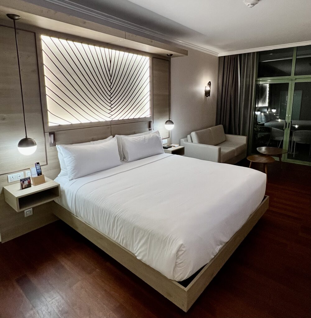a bed with white sheets and a lamp