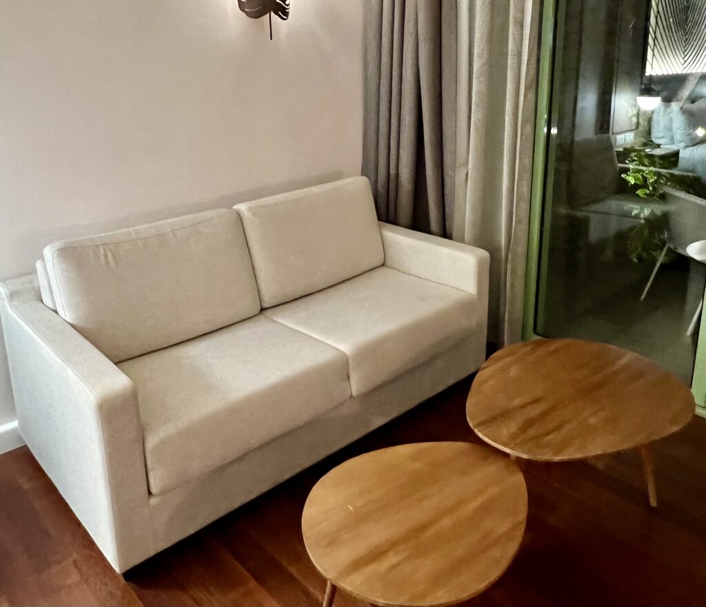 a white couch and two round tables in a room